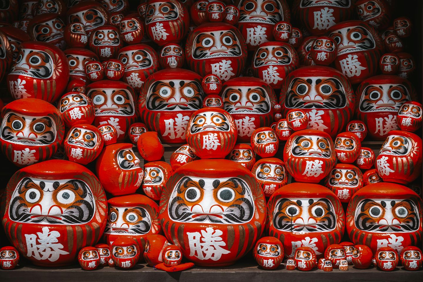 Striking round red wooden statues of faces in Japan