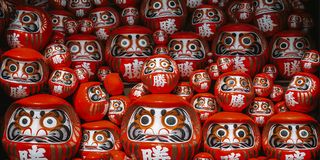 Striking round red wooden statues of faces in Japan