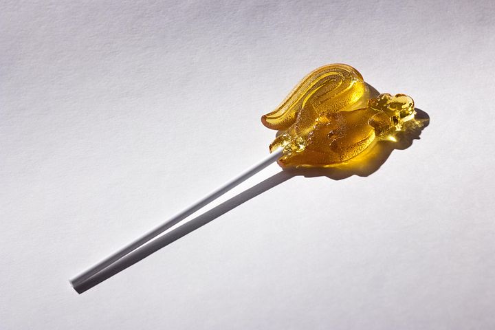 An amber-colored lollipop candy.