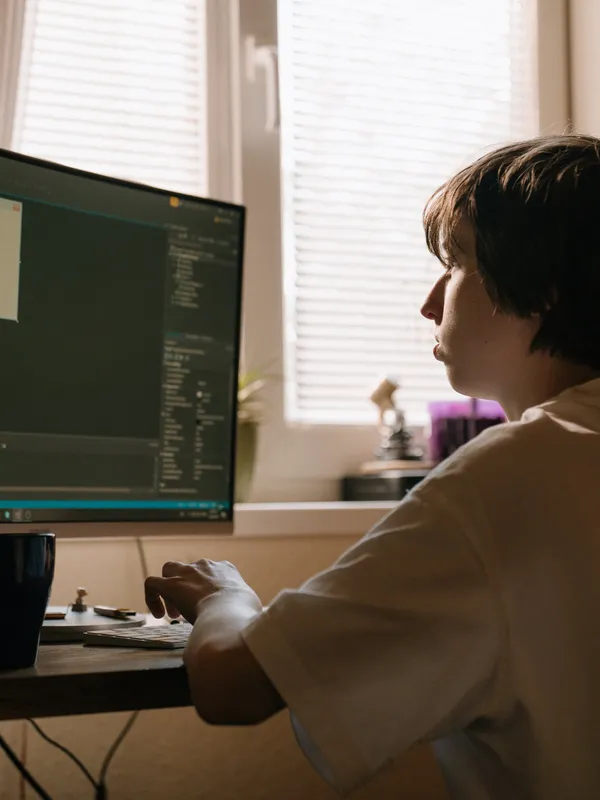 person sitting at computer coding
