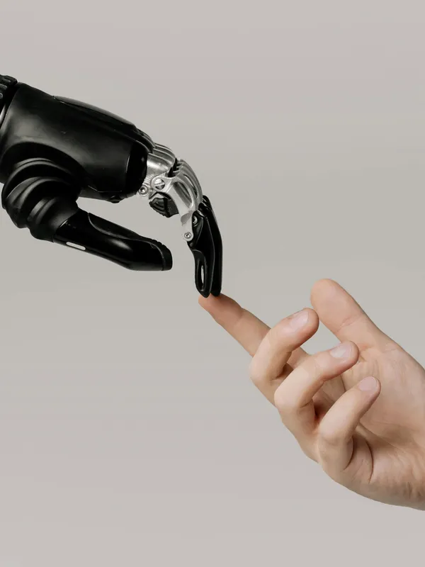 a human hand and a robot hand touching fingers