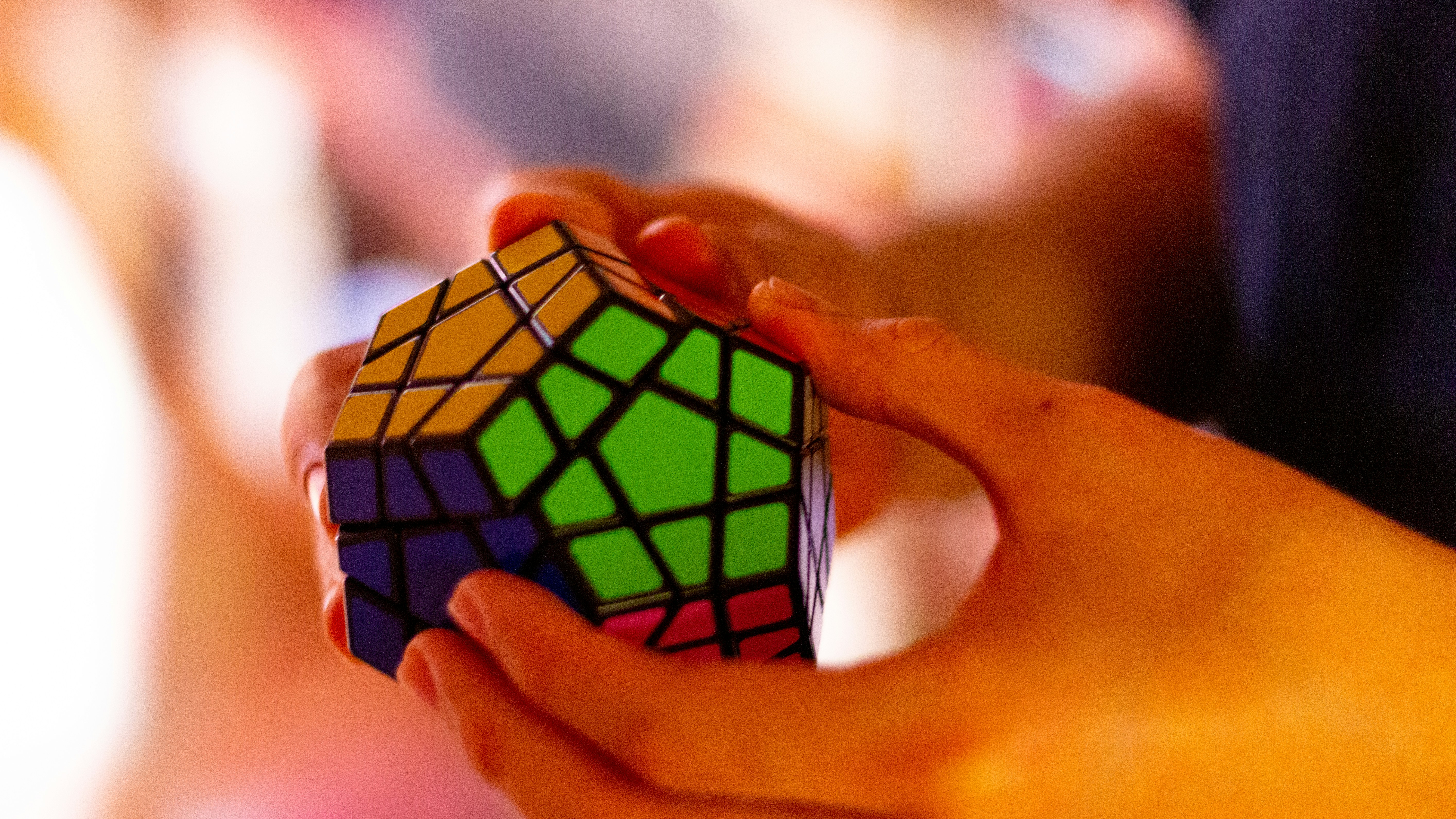 "A solved 3x3 Rubik's Cube placed on a wooden surface, brightly lit with soft natural light, highlighting its colorful red, blue, green, yellow, orange and white tiles.