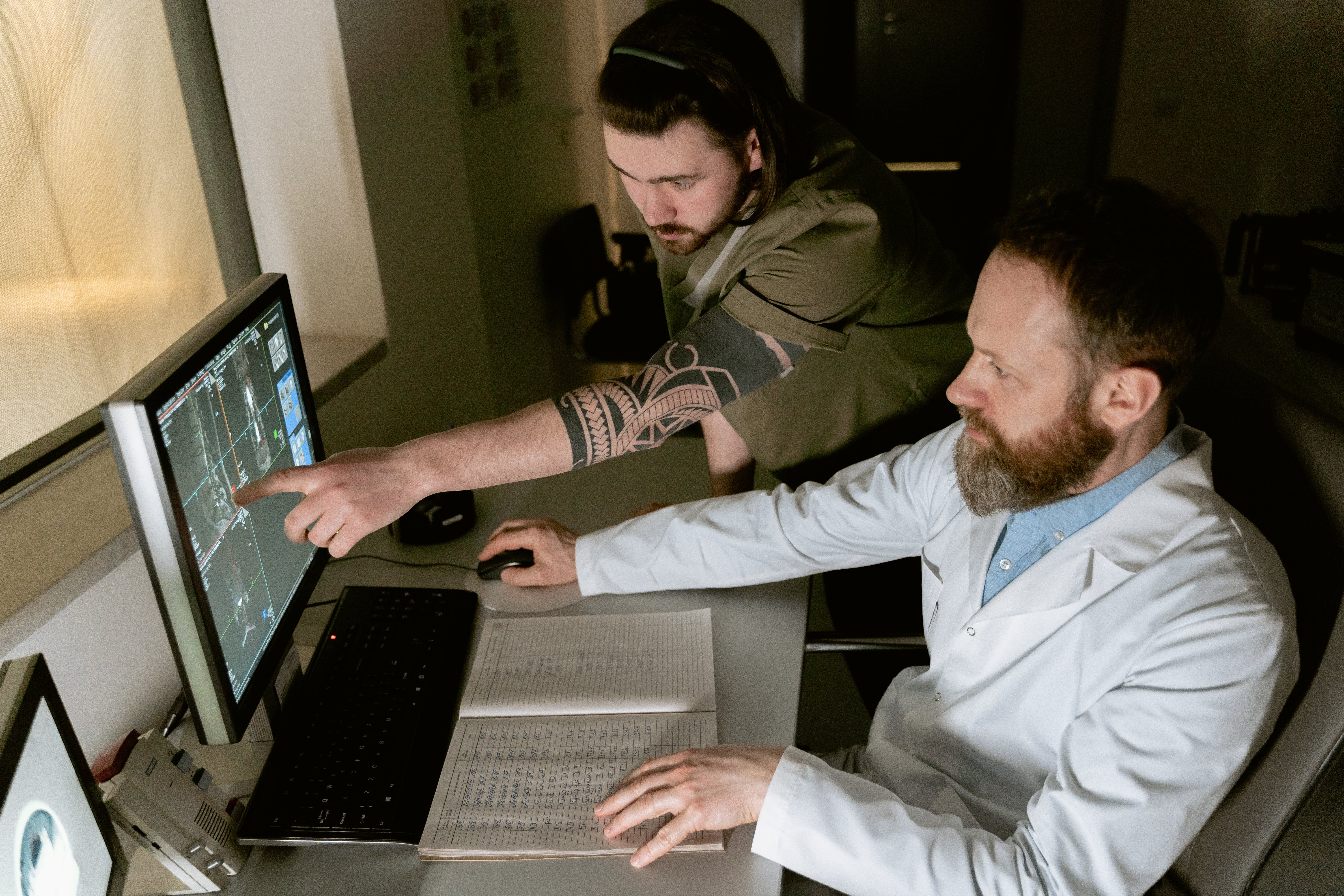 doctor and patient using health tech to input healthcare data on computer