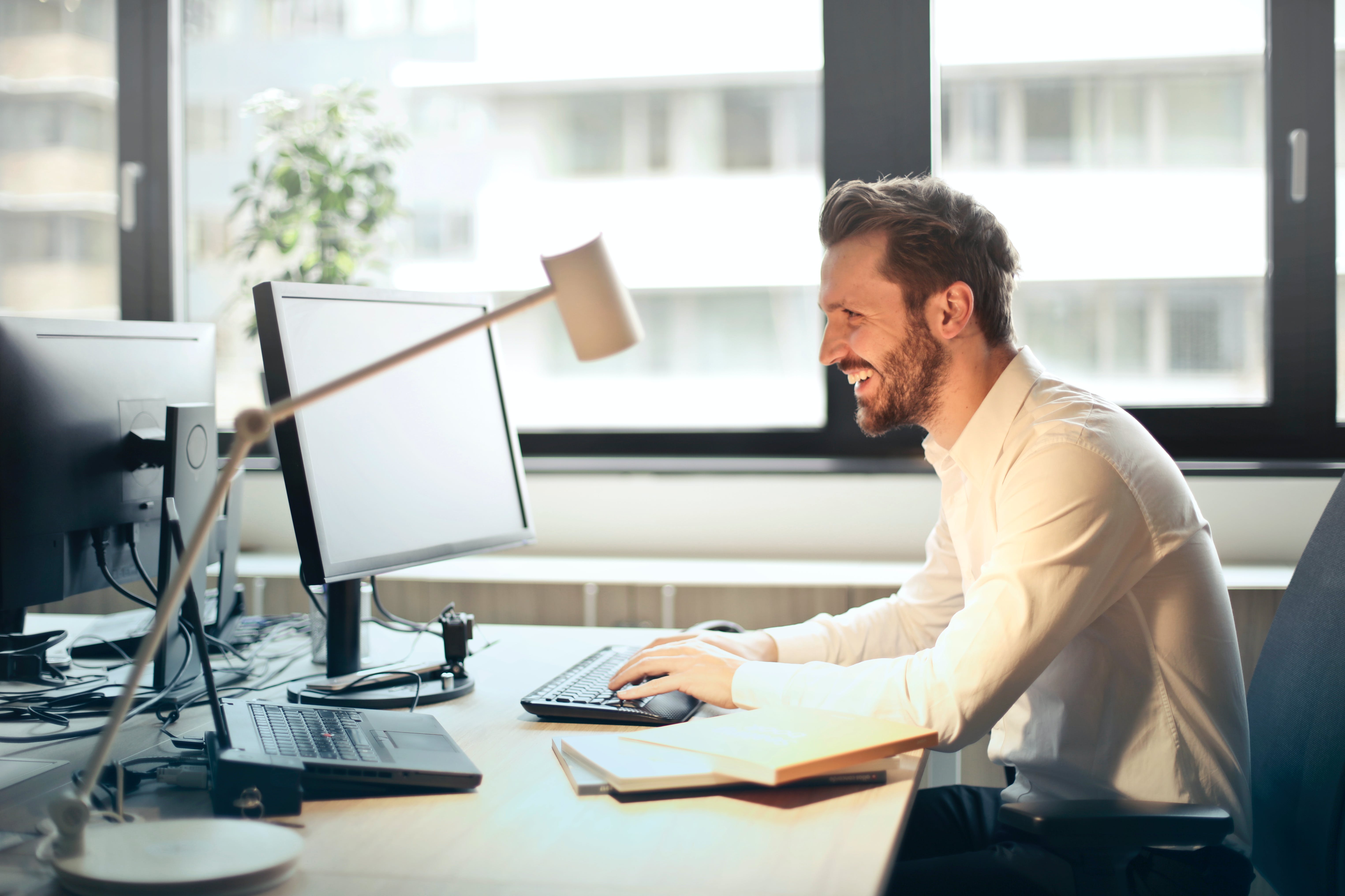 Man researching public relations agency on computer sitting on desk.