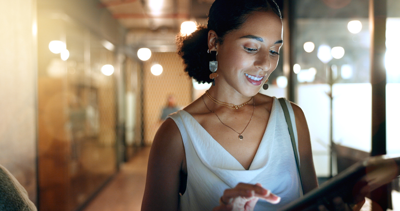 woman smiling looking at playbook on a tablet.