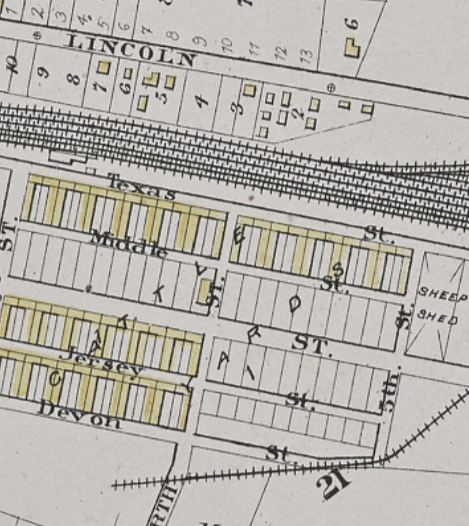 Atlas close-up of a stockyard, noting cattle breeds and a sheep pen. A rail yard crosses the top half horizontally, and above it runs a street titled Lincoln.