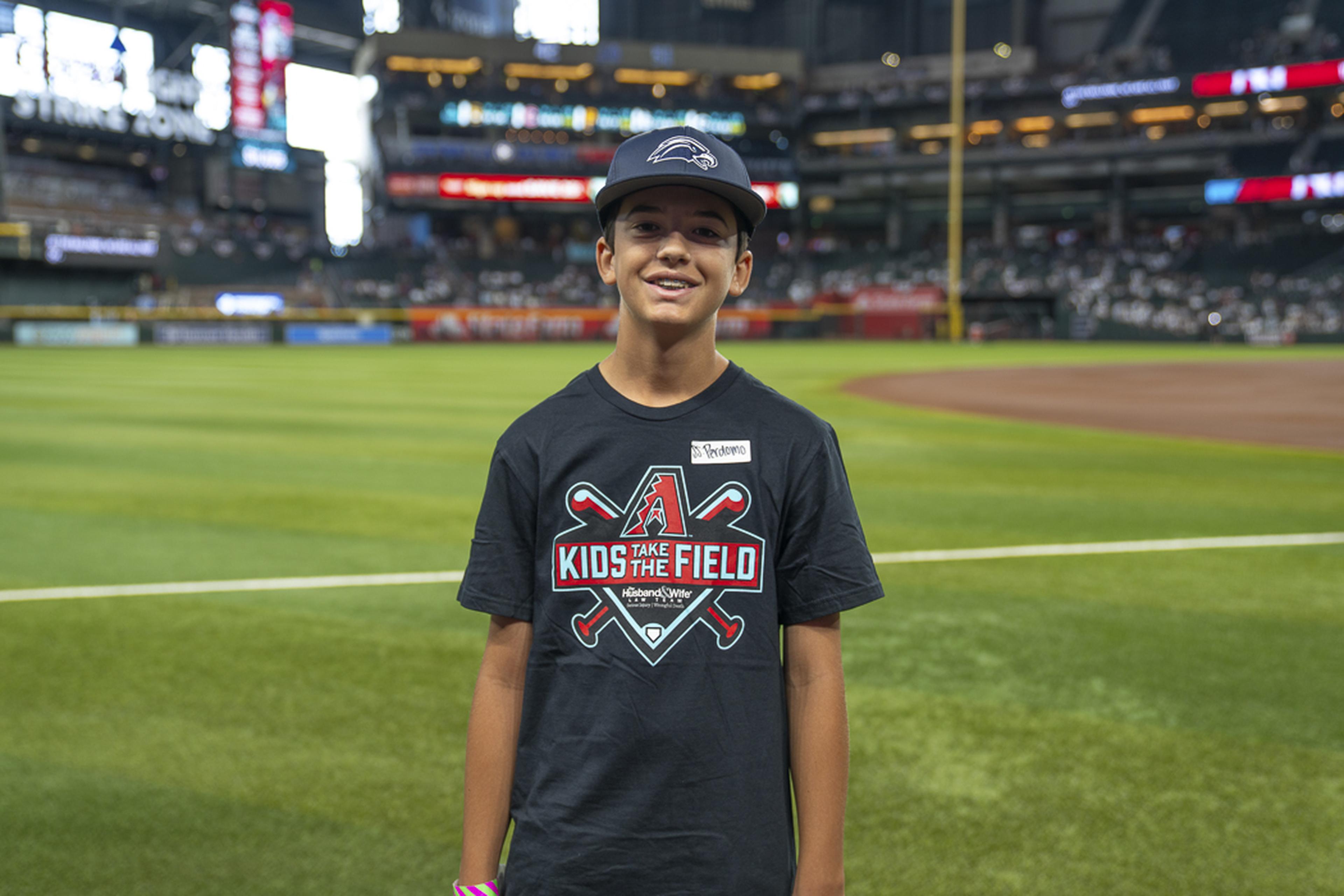 A young Kids Take the Field participant stands proudly on the field, taking in the excitement of a special day at Chase Field and creating memories that will last a lifetime.
