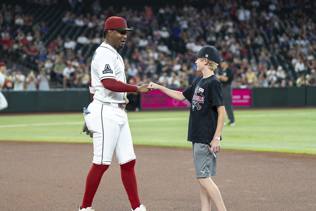 A young fan enjoys a special on-field interaction with an Arizona Diamondbacks player, making his Kids Take the Field experience one he will never forget.