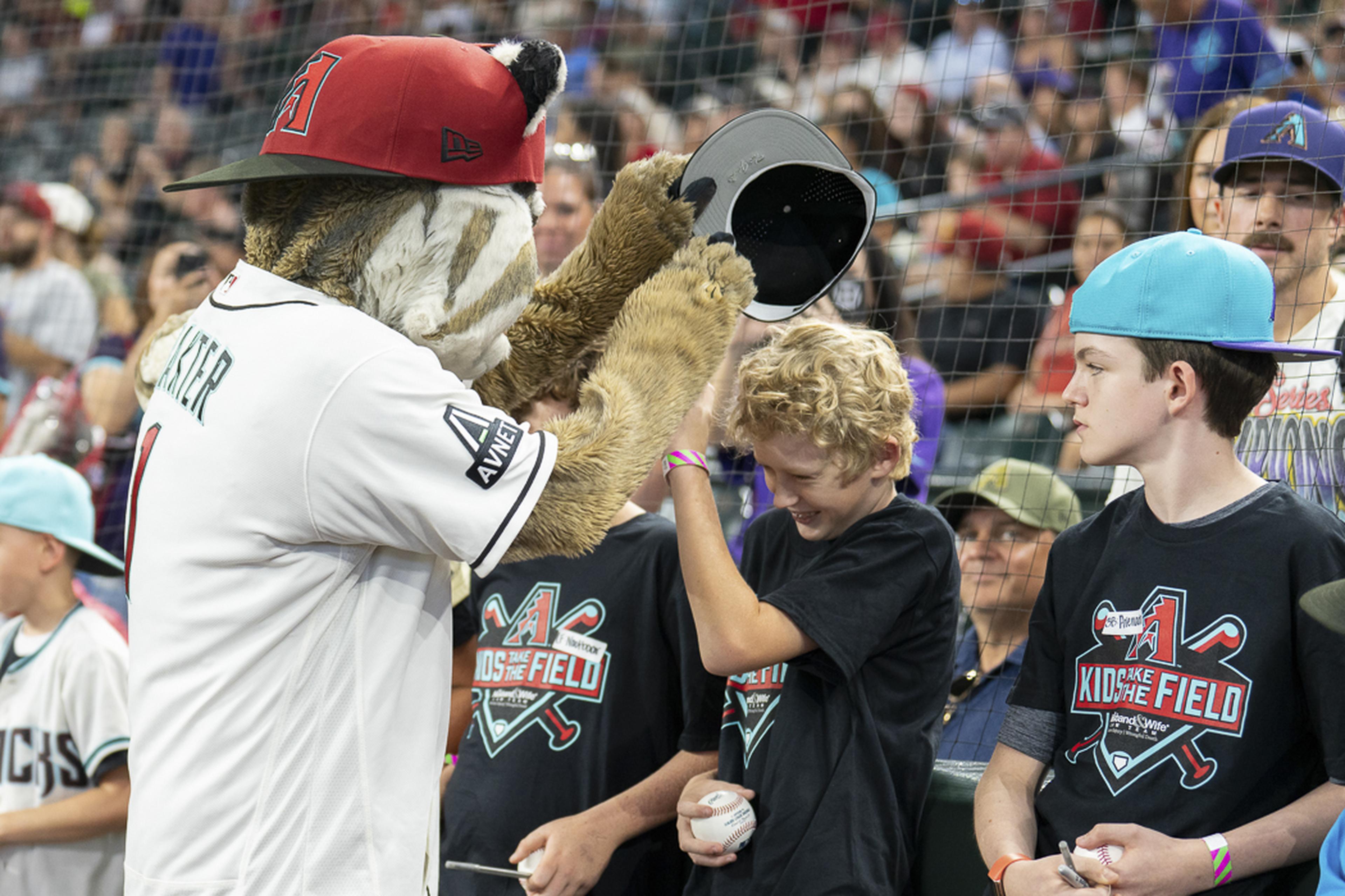 Baxter shares smiles and high-fives with excited Kids Take the Field participants, creating unforgettable memories on the field before the game at Chase Field.