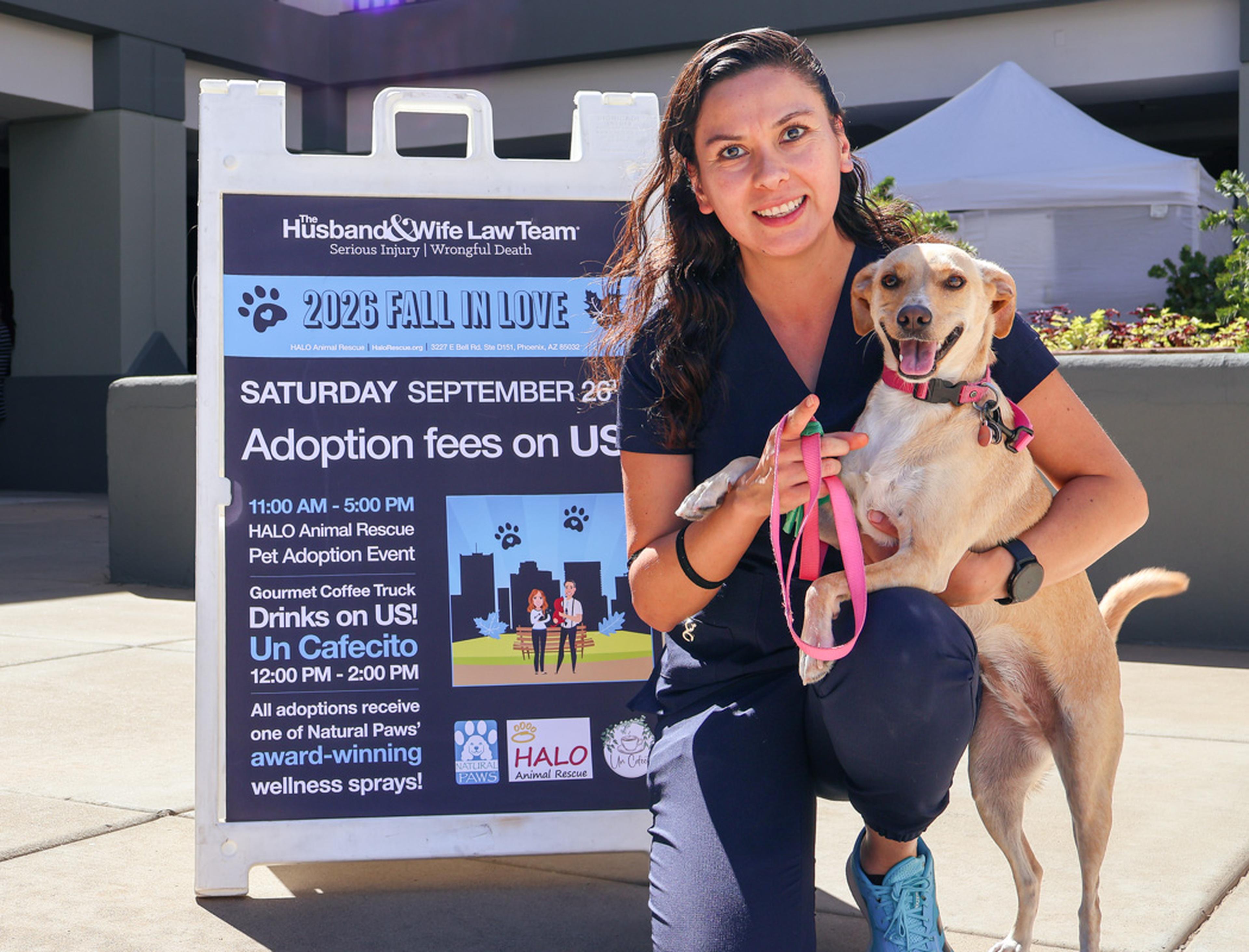 A newly adopted dog shares a happy moment with its new owner at the Husband & Wife Law Team’s HALO Adoption Event, celebrating the start of a loving forever home.