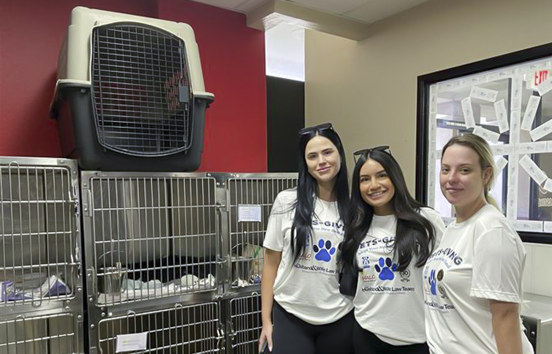 Three Husband & Wife Law Team volunteers smile together at HALO Animal Rescue, helping support pet adoption efforts and making a positive impact in the community.