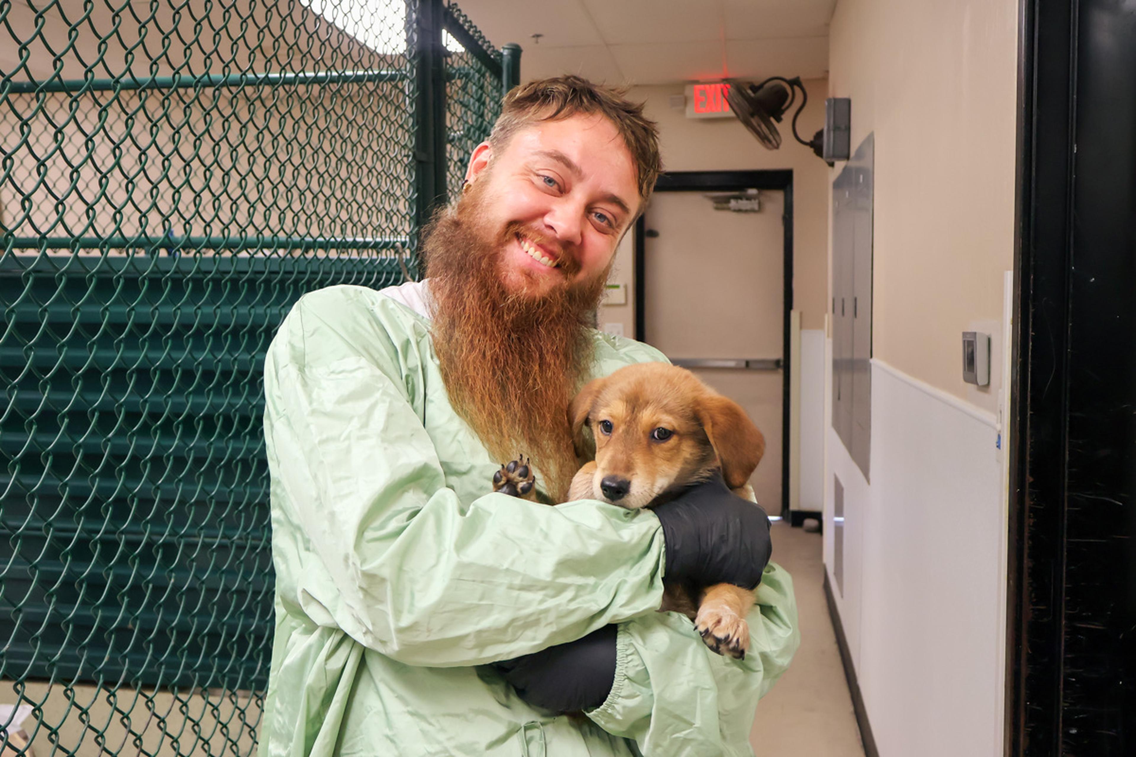 A dedicated volunteer shares a special moment with an adorable puppy at HALO Animal Rescue, helping provide care, comfort, and love while the pup waits for a forever home.