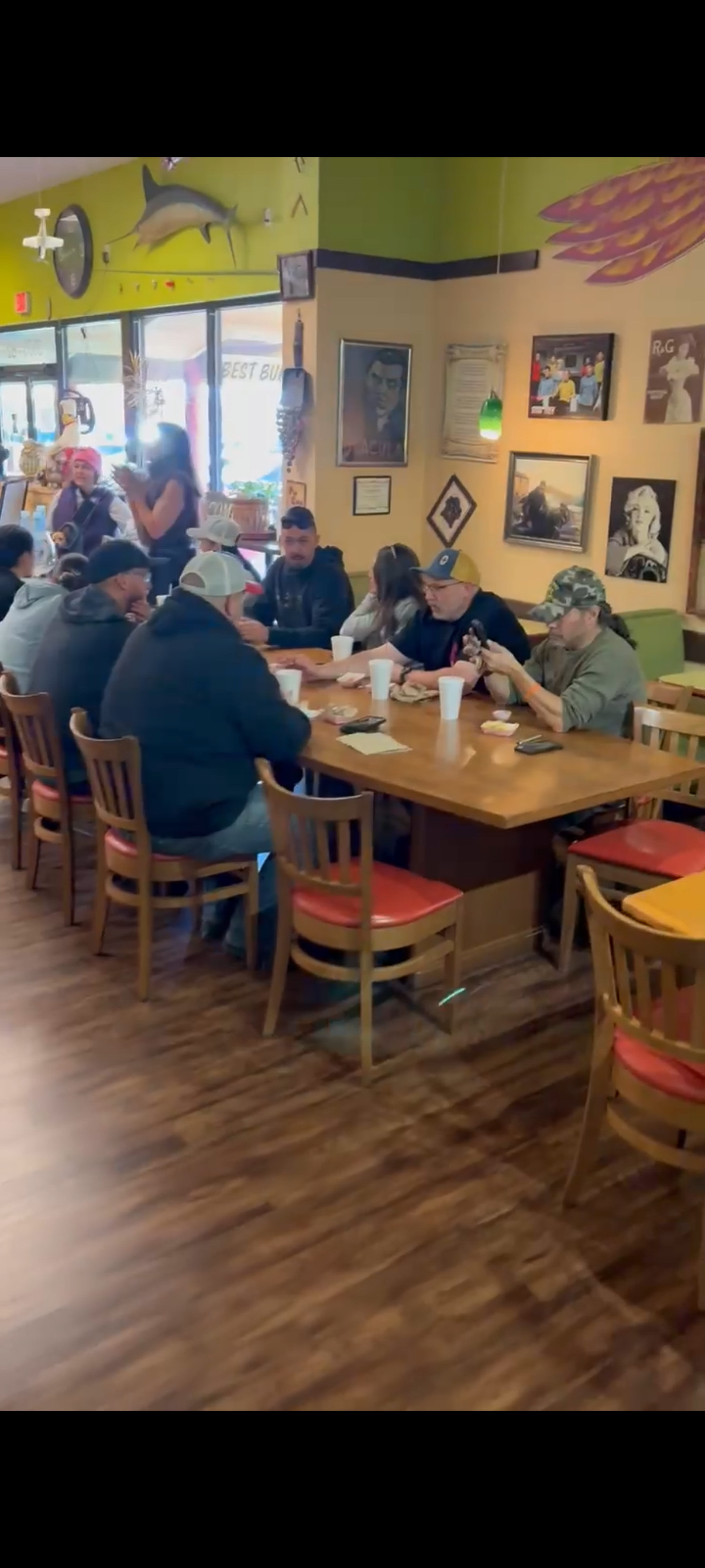 A group of people sitting at a table and enjoying food at The Grill