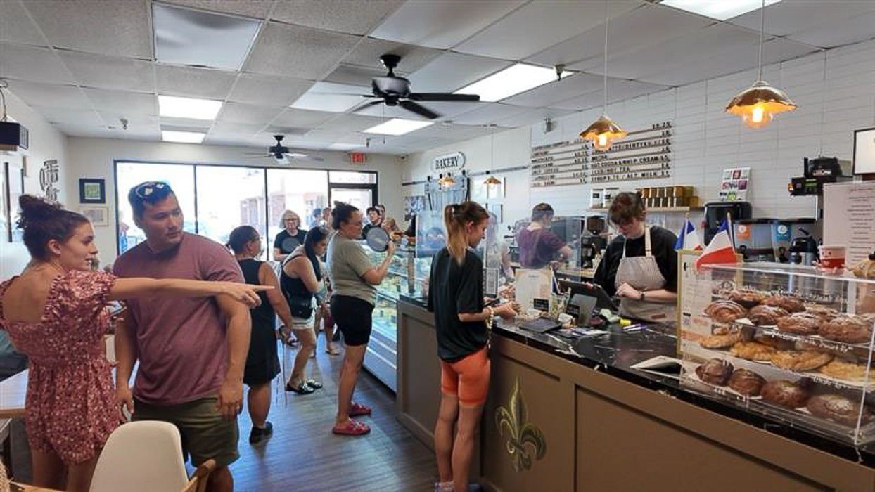Guests line up inside Quiches & Pies Bakery as fresh pastries fill the display case, creating a welcoming atmosphere during the Husband & Wife Law Team’s HEART event.