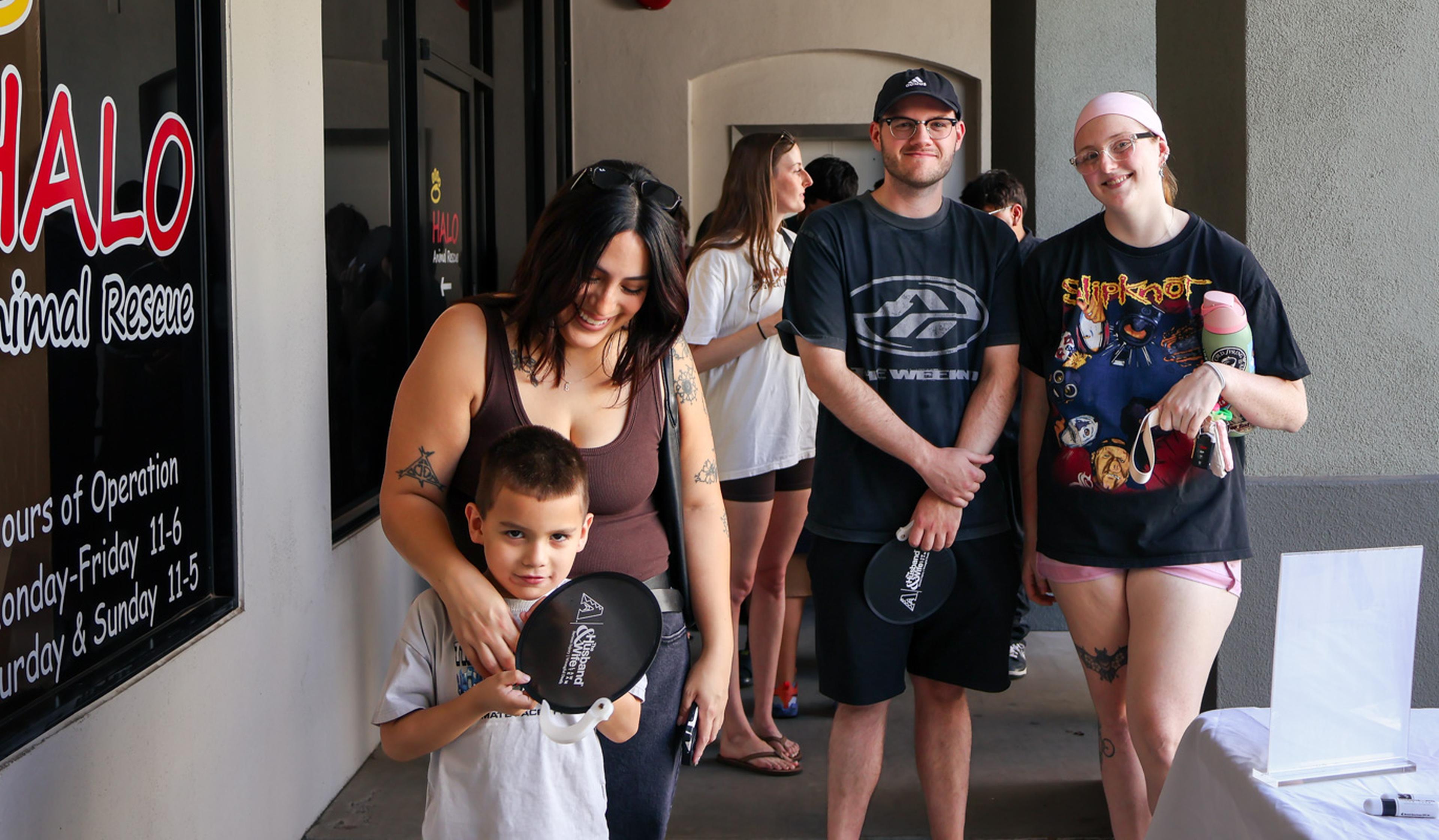 A family and friends gather outside HALO Animal Rescue during the Husband & Wife Law Team’s HALO Adoption Event, showing their support for pet adoption and helping dogs find loving forever homes.