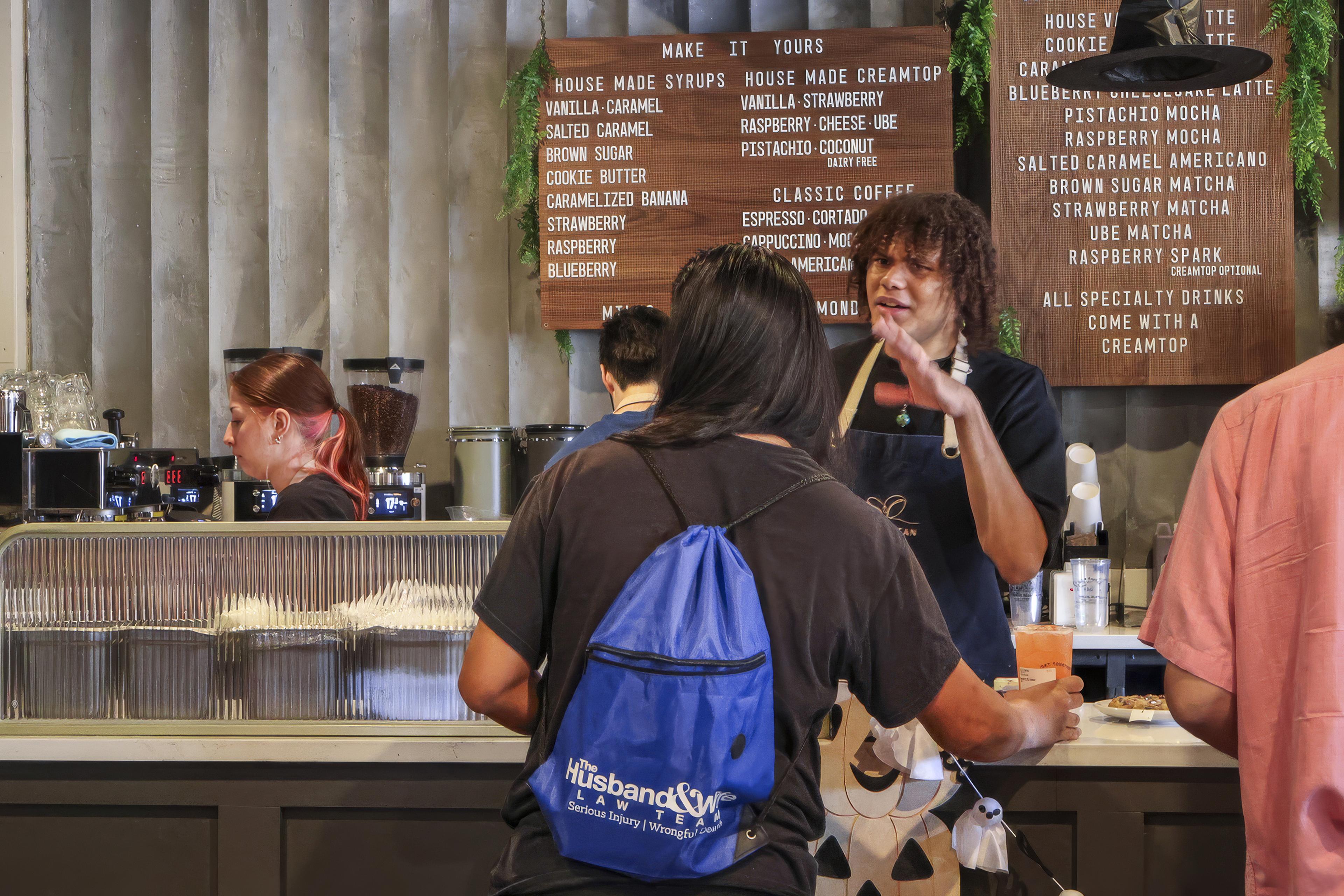 Guests place their coffee orders at Social Bean Café & Bakery during the Husband & Wife Law Team’s HEART event.
