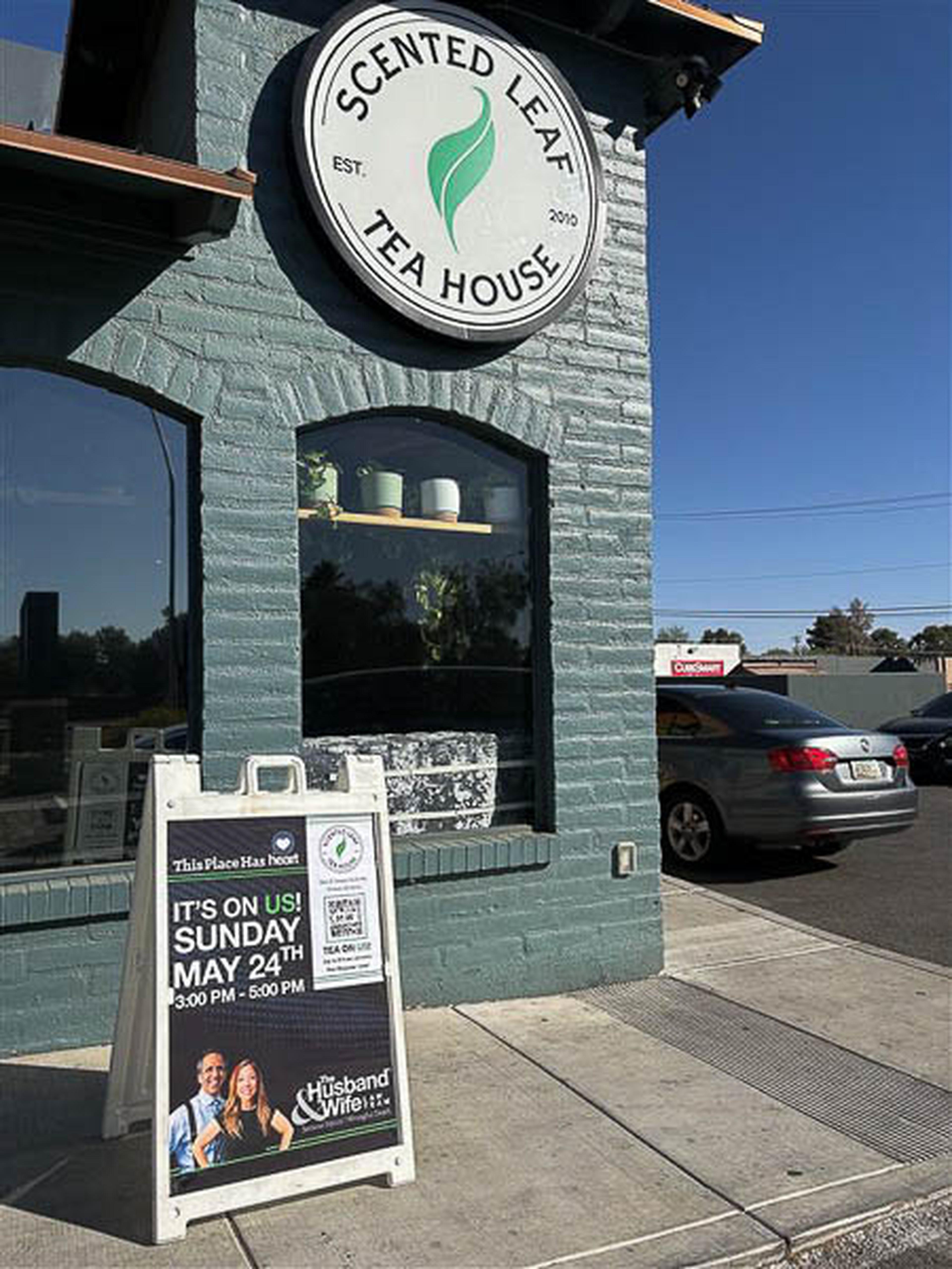 Outside Scented Leaf Tea House, a sign announces a free community event by the Husband & Wife Law Team.