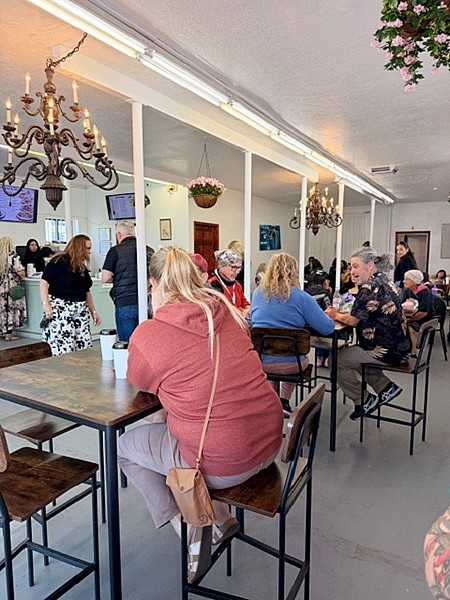 Guests chat over crepes, waffles, pancakes, and more at cozy wooden tables in the café.