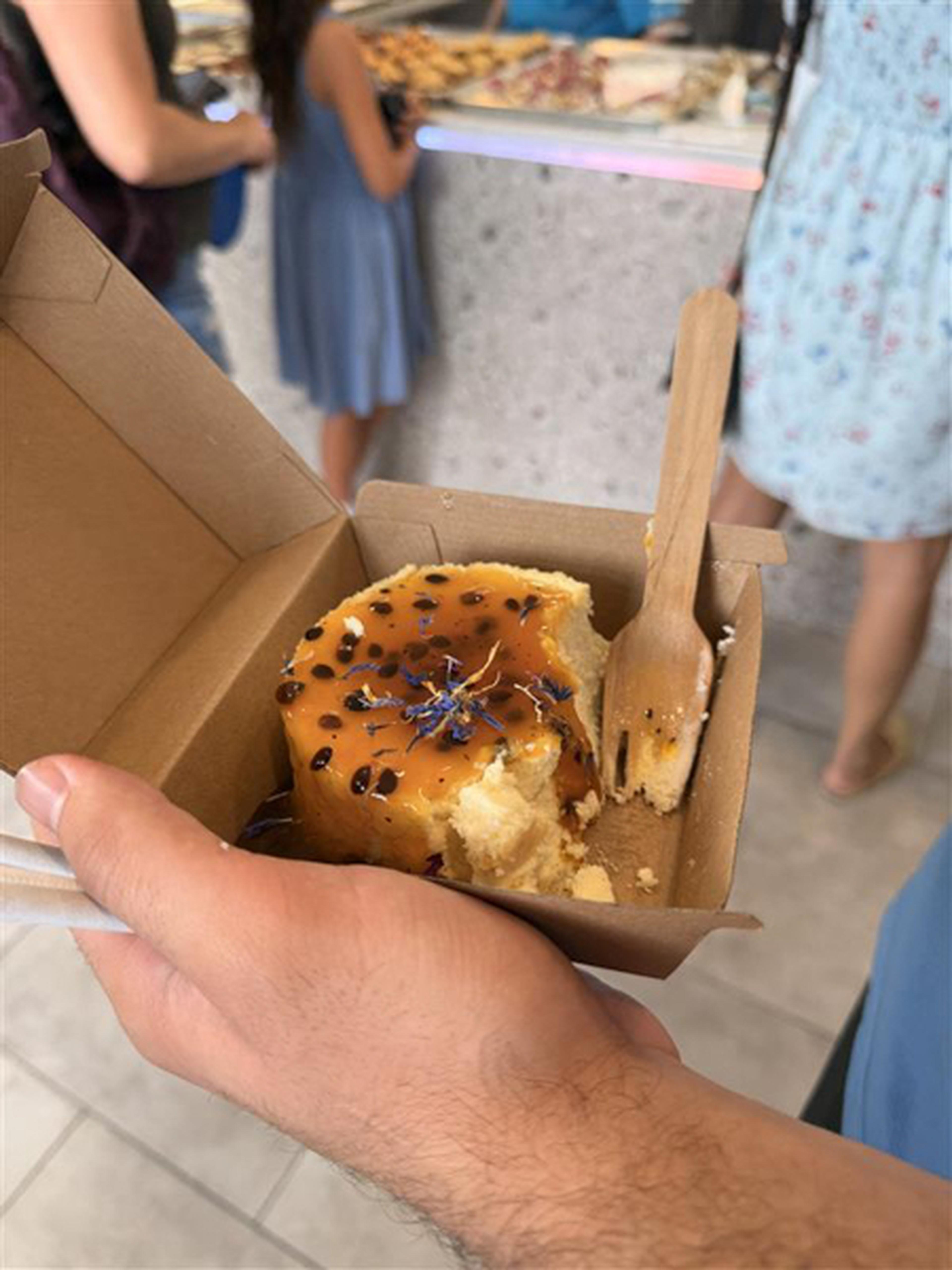 A customer is proudly showing us a delicious gluten‑free treat form the Sweet Impastries Bakery