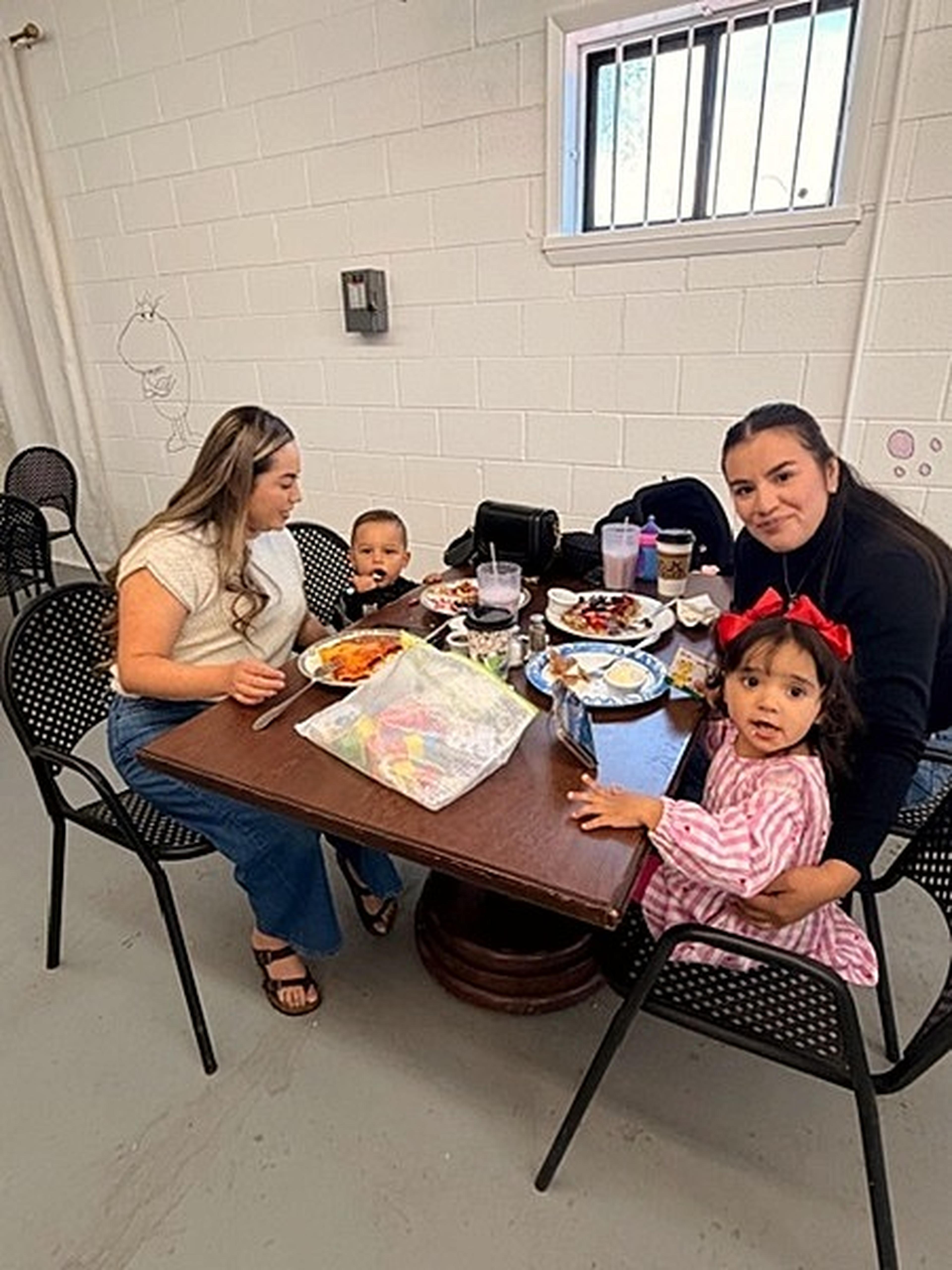 A relaxed, cheerful moment as two women and two kids enjoy their food at Milk and Honey Caffe.
