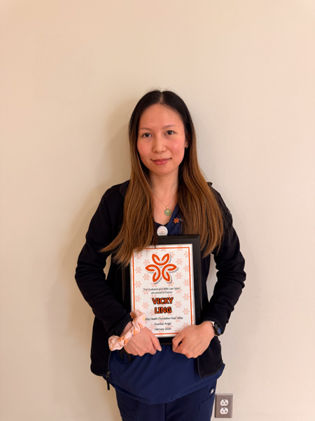 Vicky holding a framed certificate which says Guardian Angel Award. A testament to her dedication