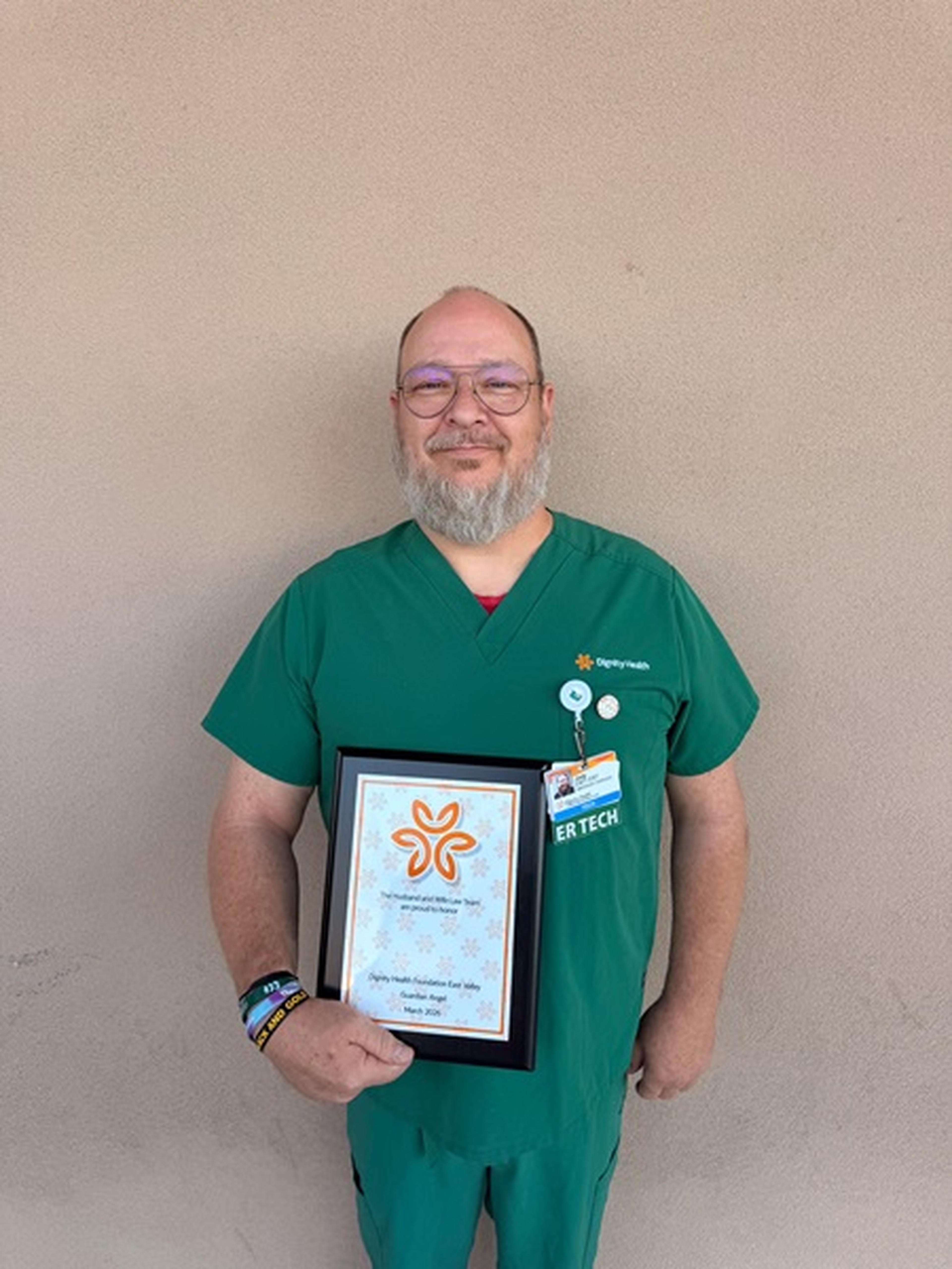 Nurse Jody smiles proudly while posing with his Guardian Angel Award.