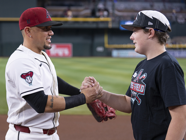 An Arizona Diamondbacks player greets a Kids Take the Field contest winner on the field, creating a memorable moment before the game.