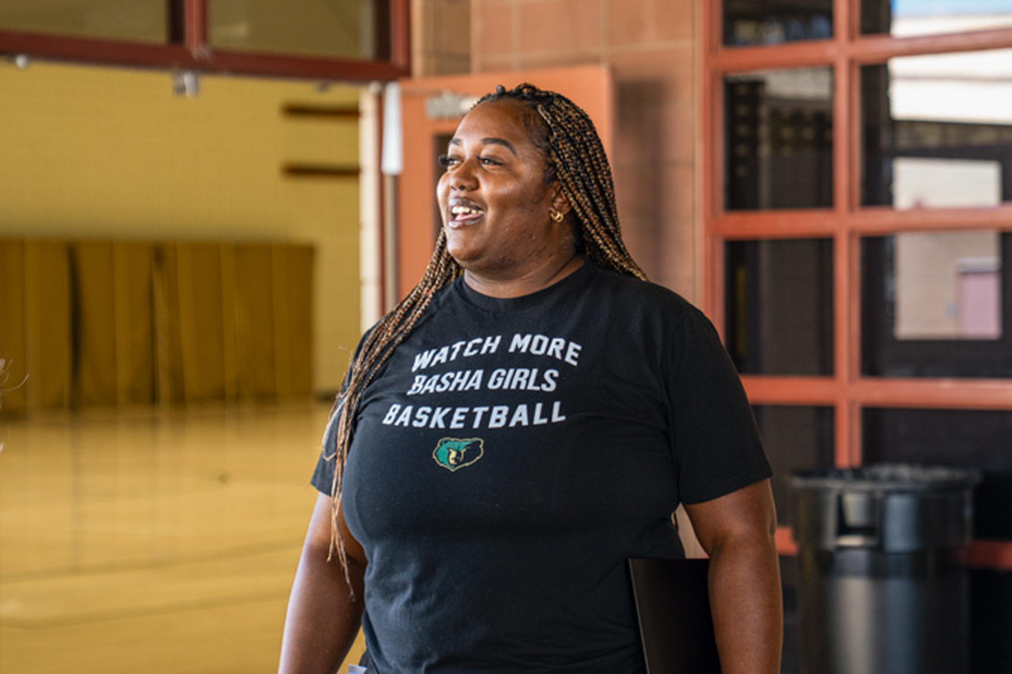 A joyful moment as Coach Bright beams after receiving The Husband & Wife Law Team’s Teacher Appreciation Award, sporting her Basha Girls Basketball tee in the gym.
