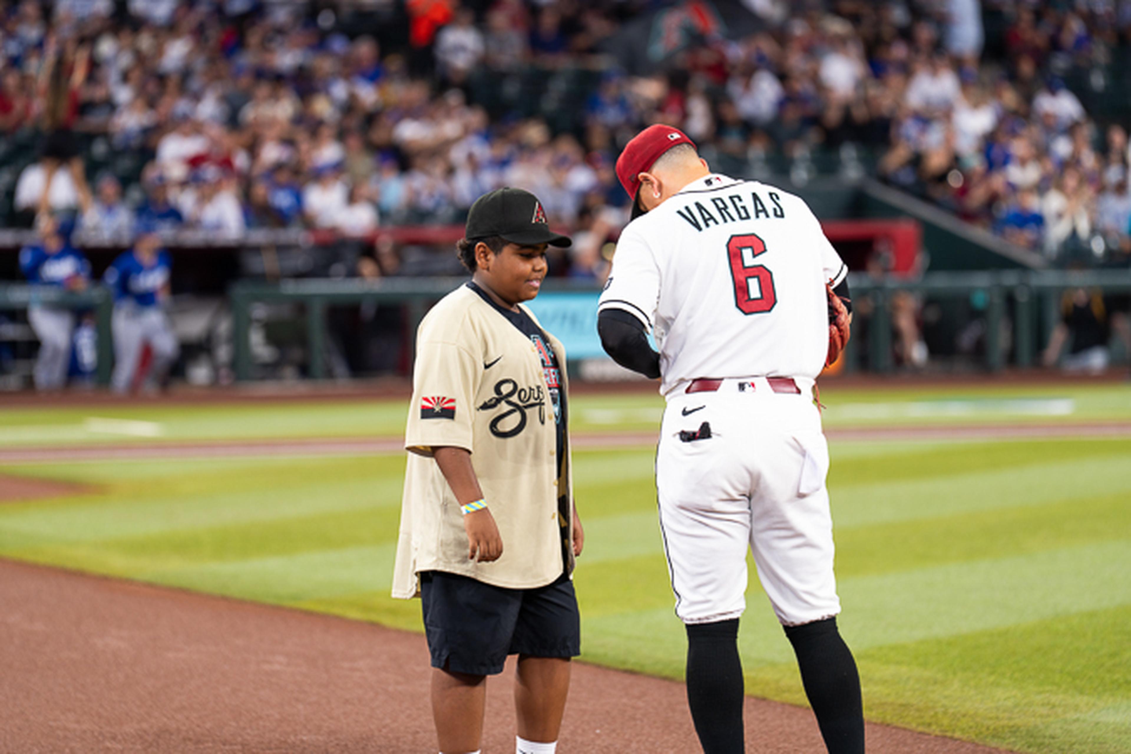 A young Kids Take the Field winner shares a special moment with an Arizona Diamondbacks player on the field, creating a memory that will last a lifetime.