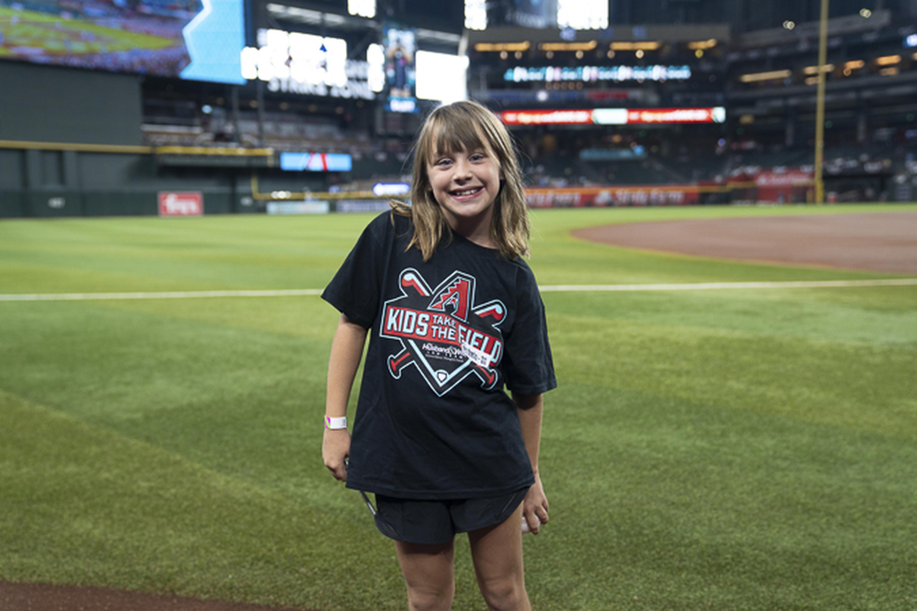 A Husband & Wife Law Team Kids Take the Field contest winner smiles on Chase Field, enjoying a once-in-a-lifetime experience at the home of the Arizona Diamondbacks.