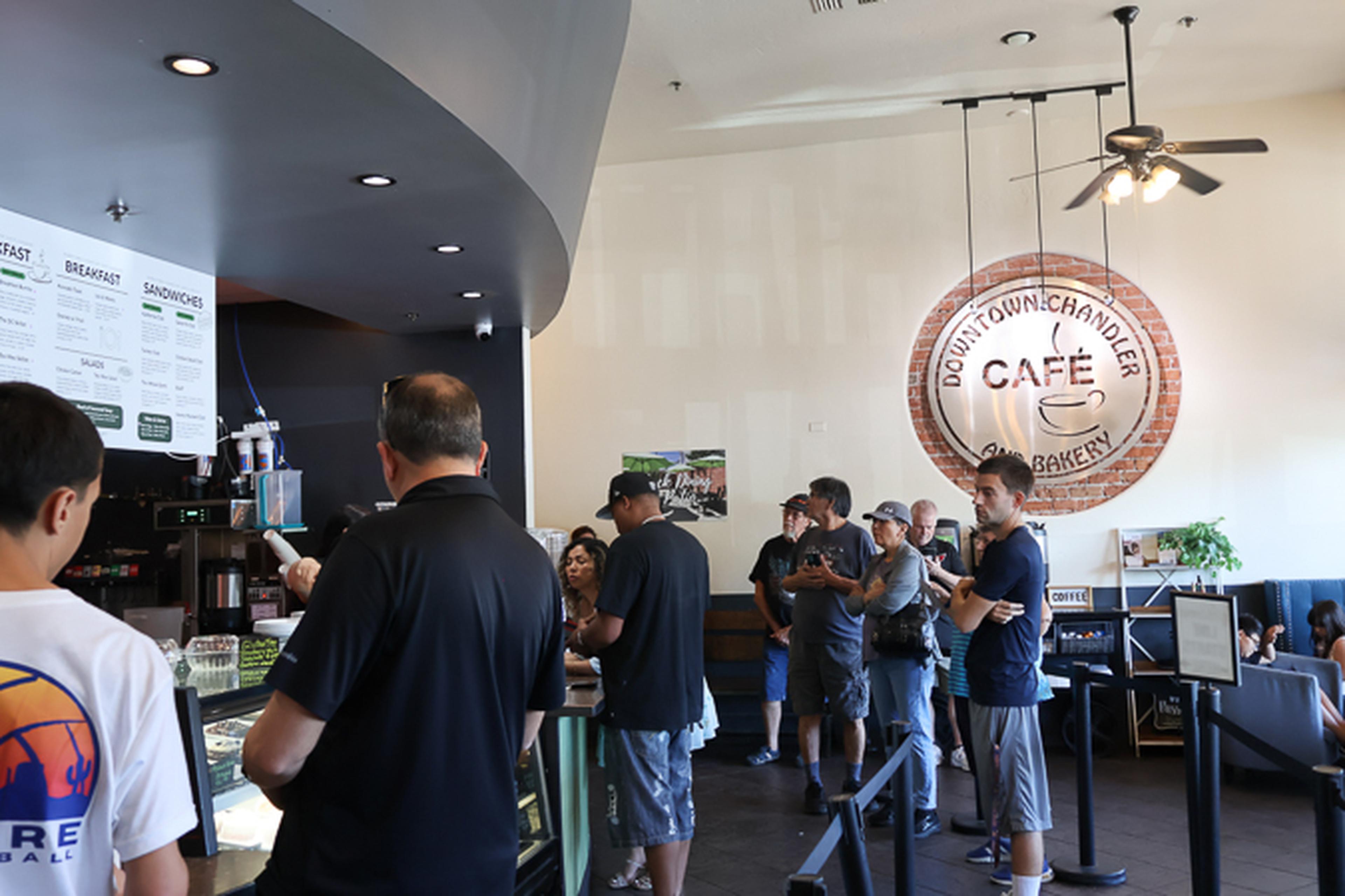 Guests line up inside Downtown Chandler Cafe & Bakery, creating a lively atmosphere as community members gather to enjoy local favorites during the Husband & Wife Law Team's HEART event.