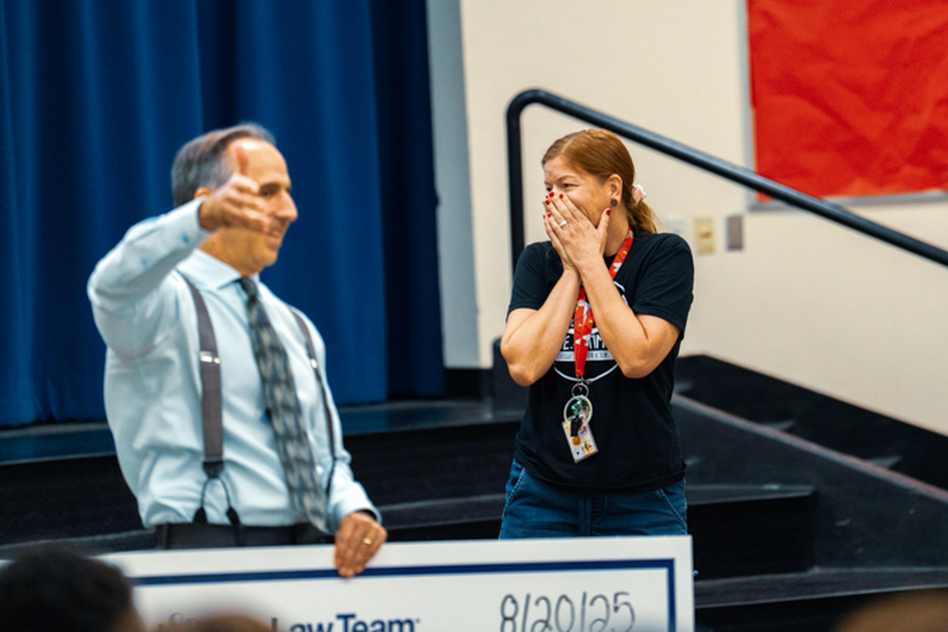 Mrs. Bailey holds her hands over her mouth in excitement as Mark gestures to the children