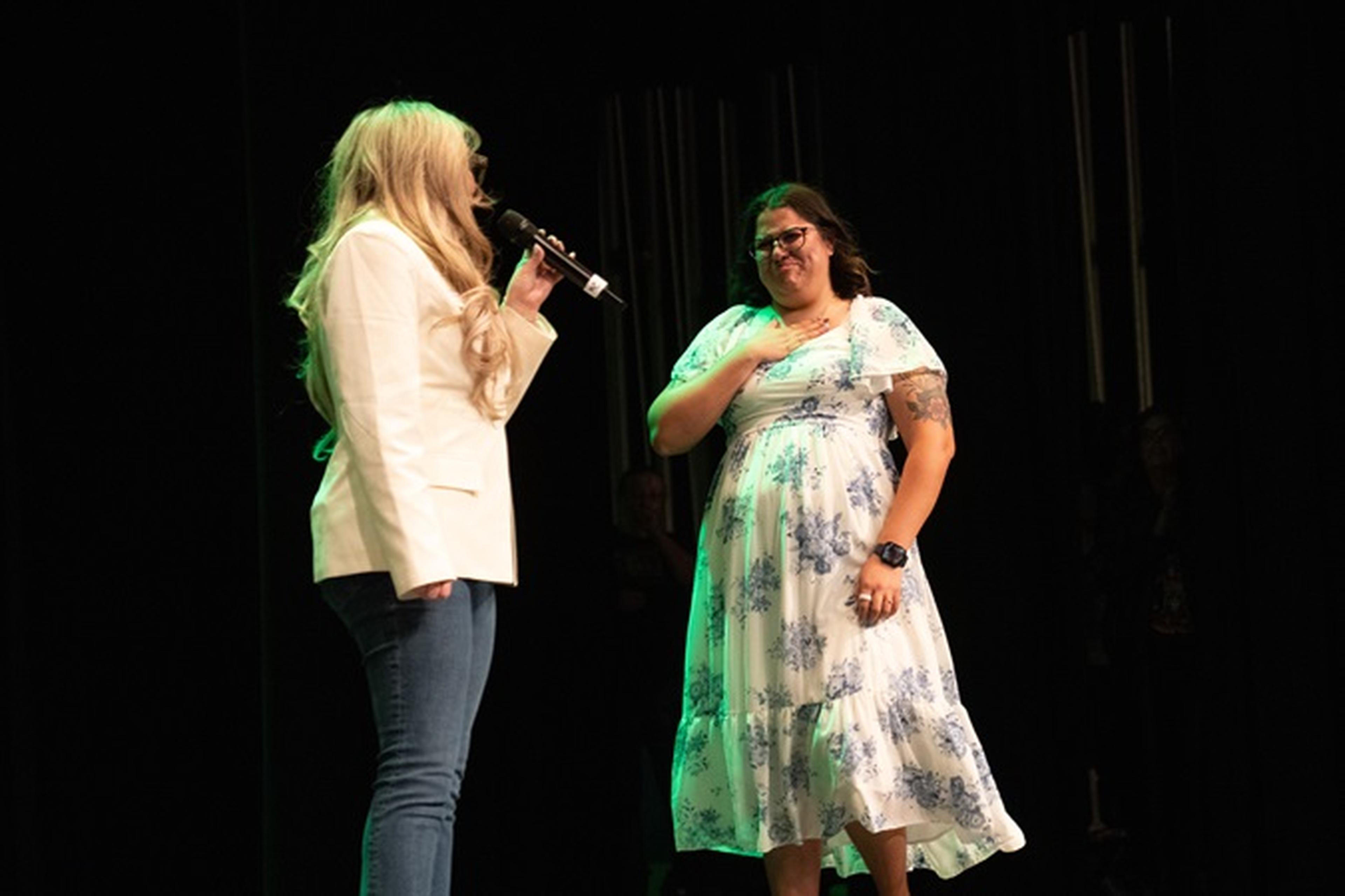 Ms. Johnson of Skyline High School smiles in surprise, hand over her heart, as she’s honored with the Husband and Wife Teacher Appreciation Award.