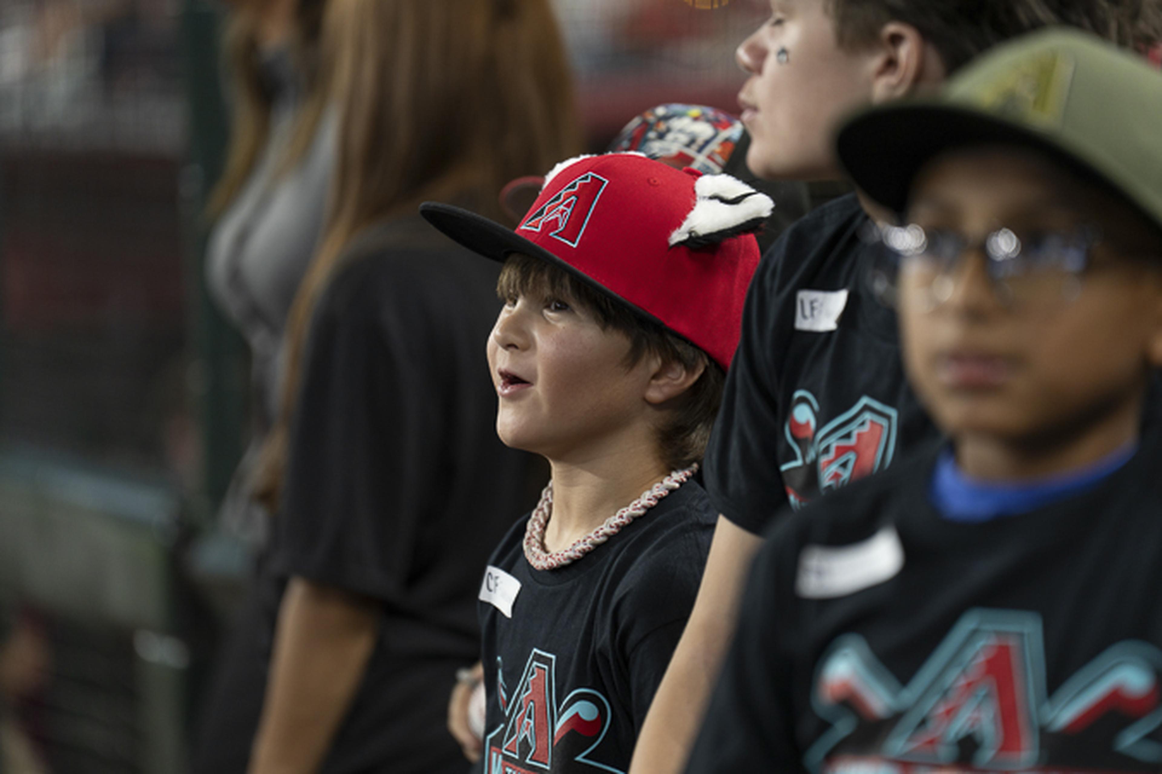 A young fan in a red cap watches the excitement unfold, taking in every moment of this unforgettable baseball experience.