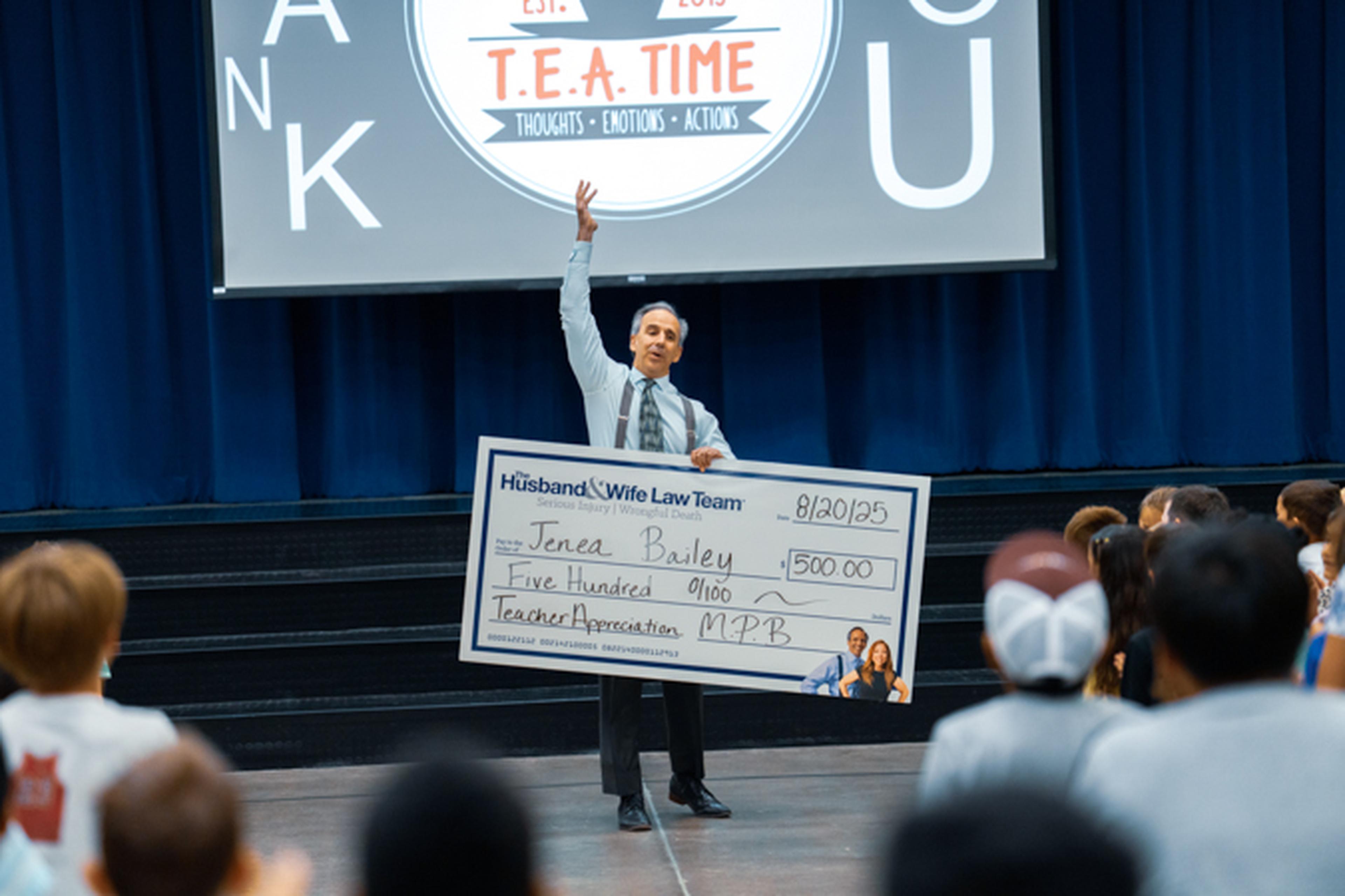 Mark Breyer holding the big check for Teacher Appreciation
