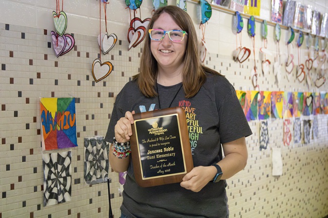 Ms. Noble of Zuni Technology & Communication Magnet School holds a plaque and a $500 “Teacher of the Month” check.