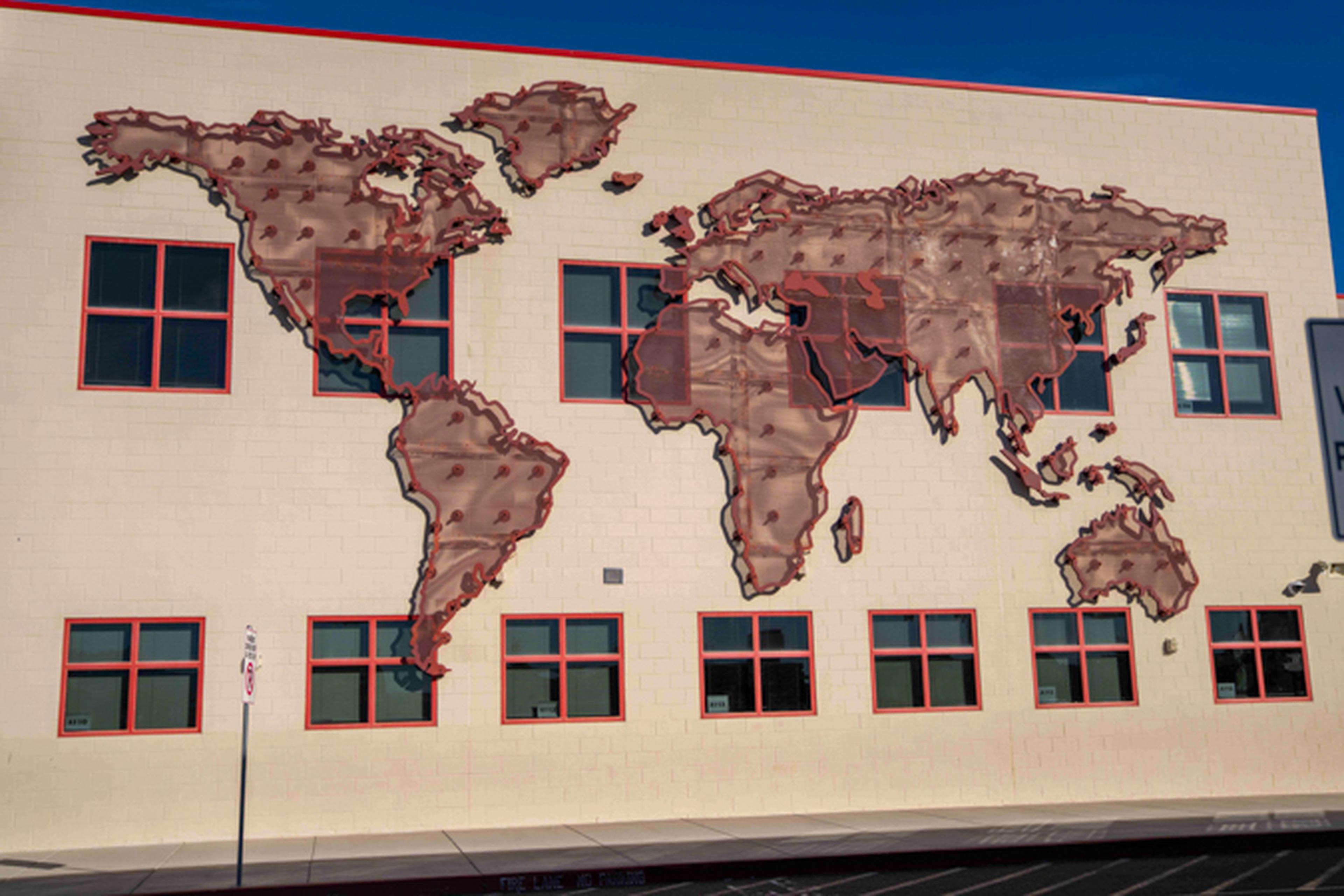 School building with a 3-dimensional world map attached to the outside wall