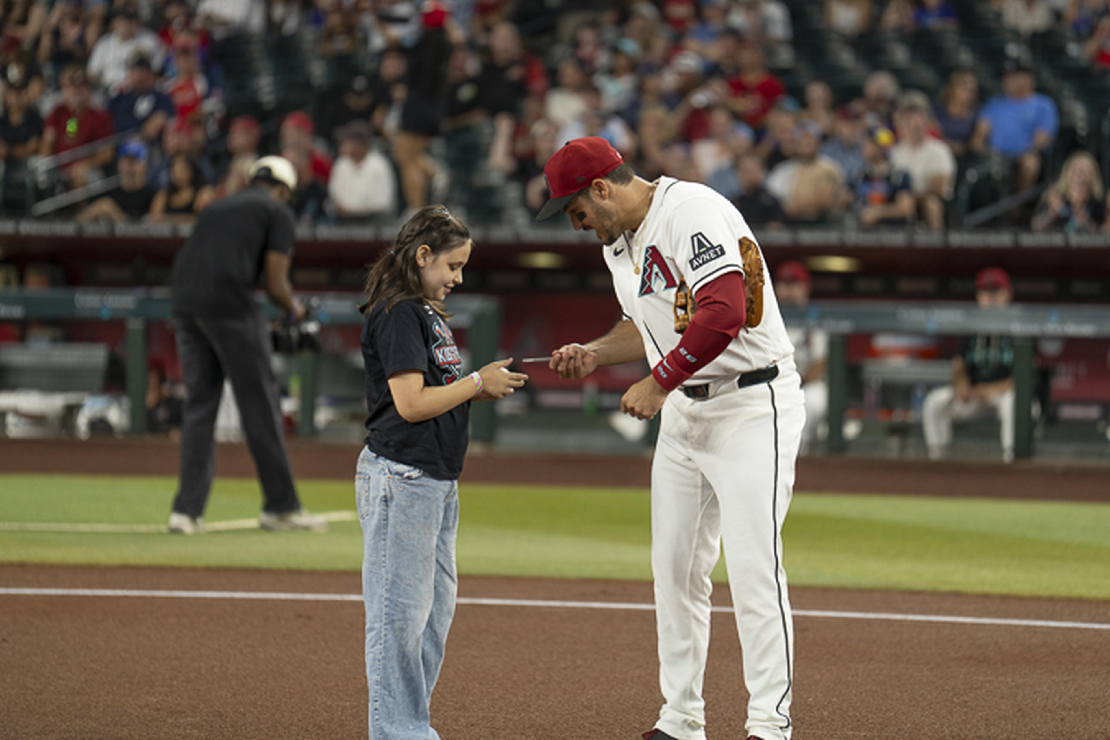 A Diamondbacks player makes a young fan’s day, signing an autograph during an unforgettable Kids Take the Field experience.