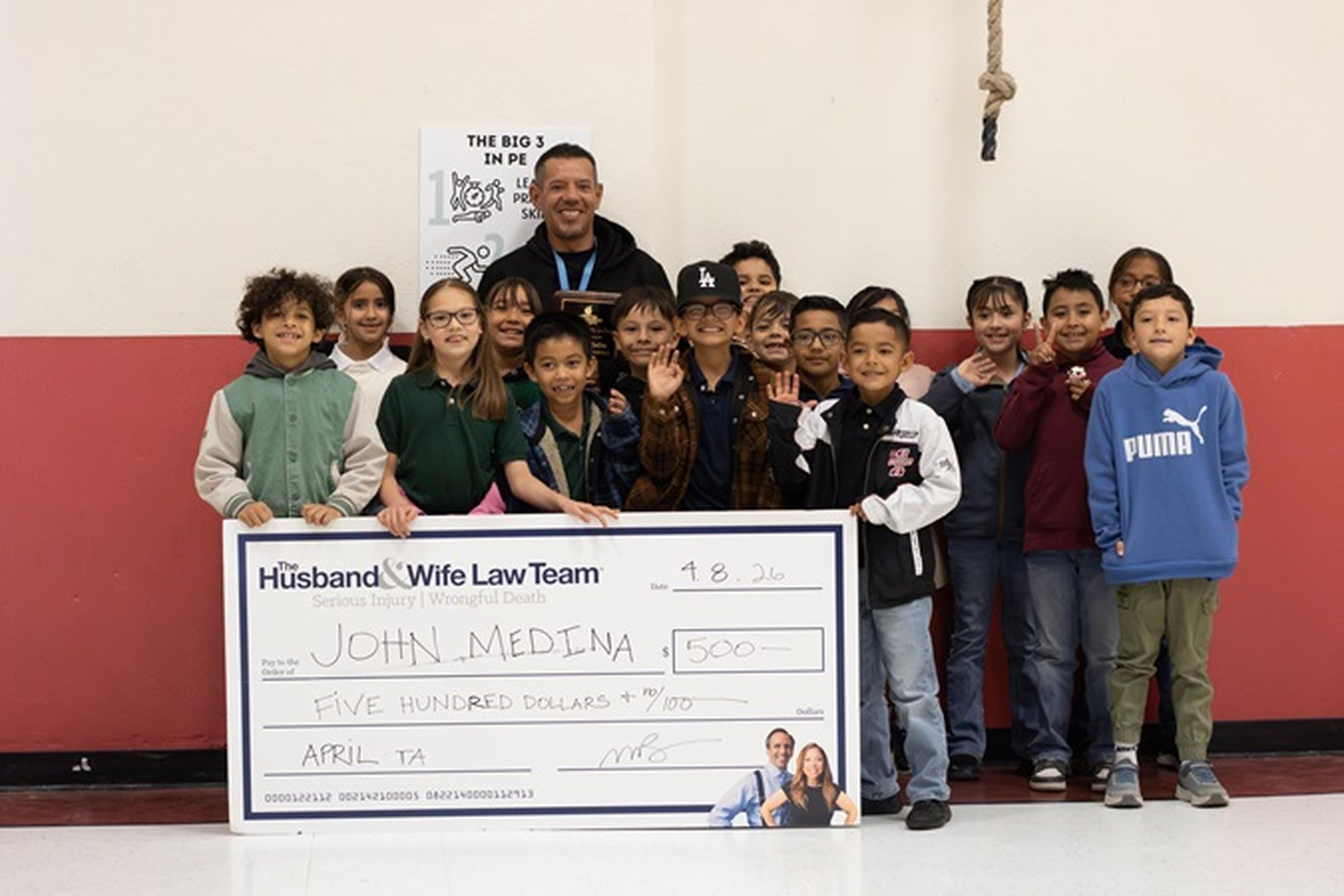 Mr. Medina and his students pose with a $500 check and this month’s Teacher Appreciation Award.