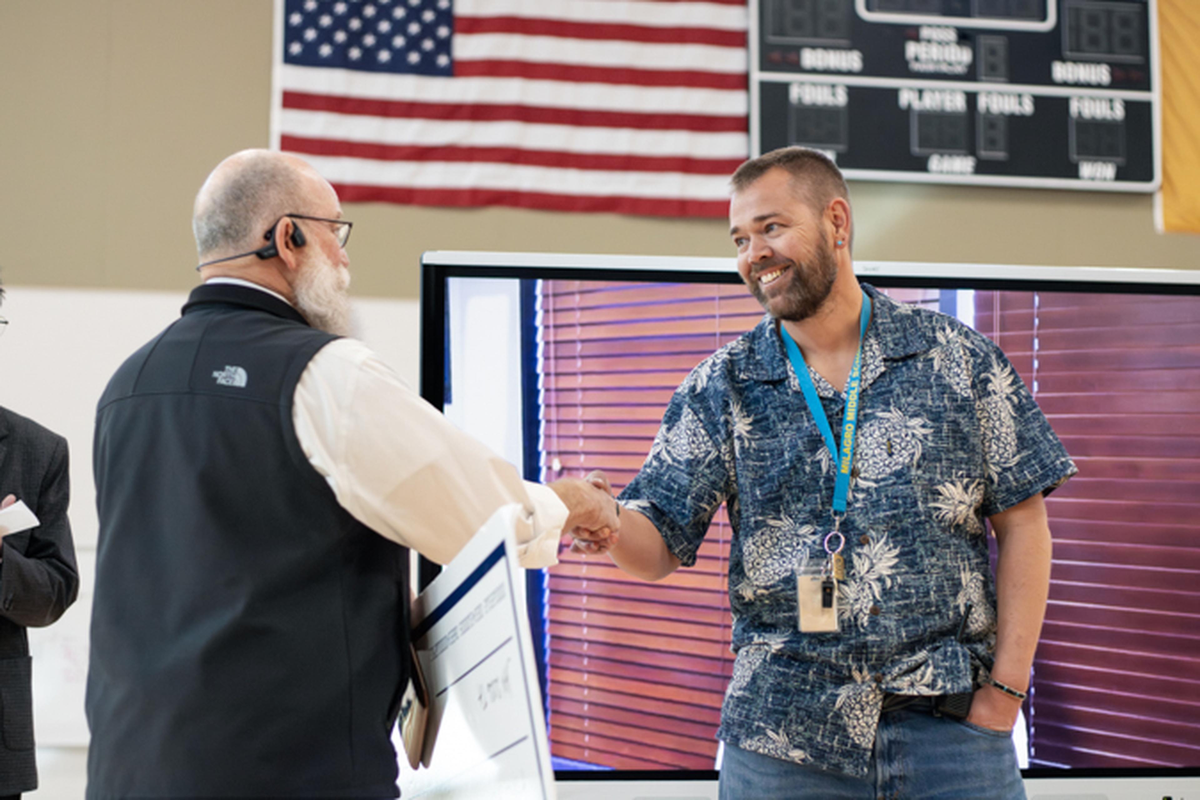Rick Cravens holding a certificate for Mr. Johnson