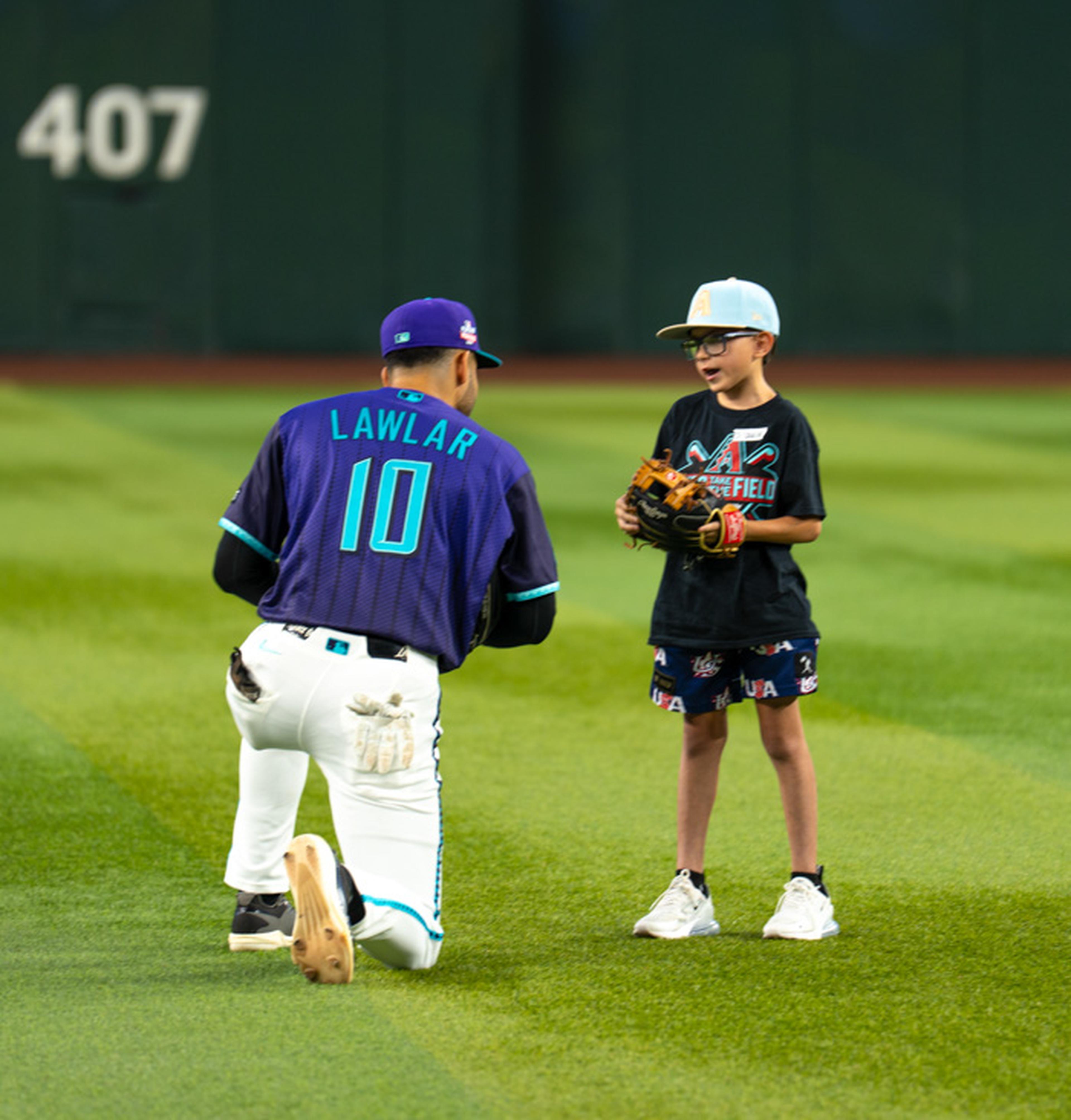 An Arizona Diamondbacks player takes a moment to connect with a young Kids Take the Field participant, creating a memorable on-field experience before the game.