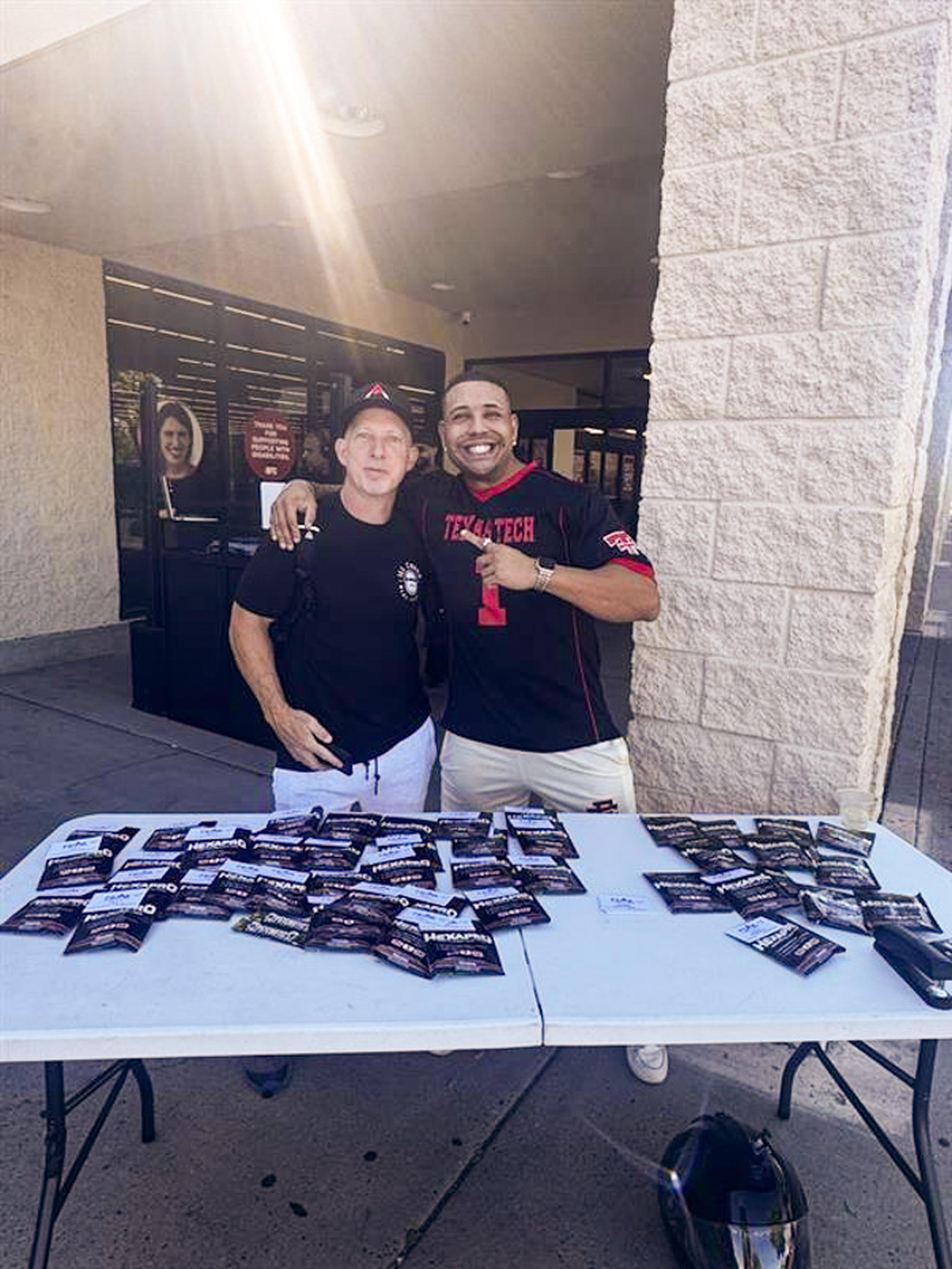 Two attendees smile outside Ill Chino Meal Service during the Husband & Wife Law Team’s HEART event, with one proudly showing off his Texas Tech jersey while connecting with the community.