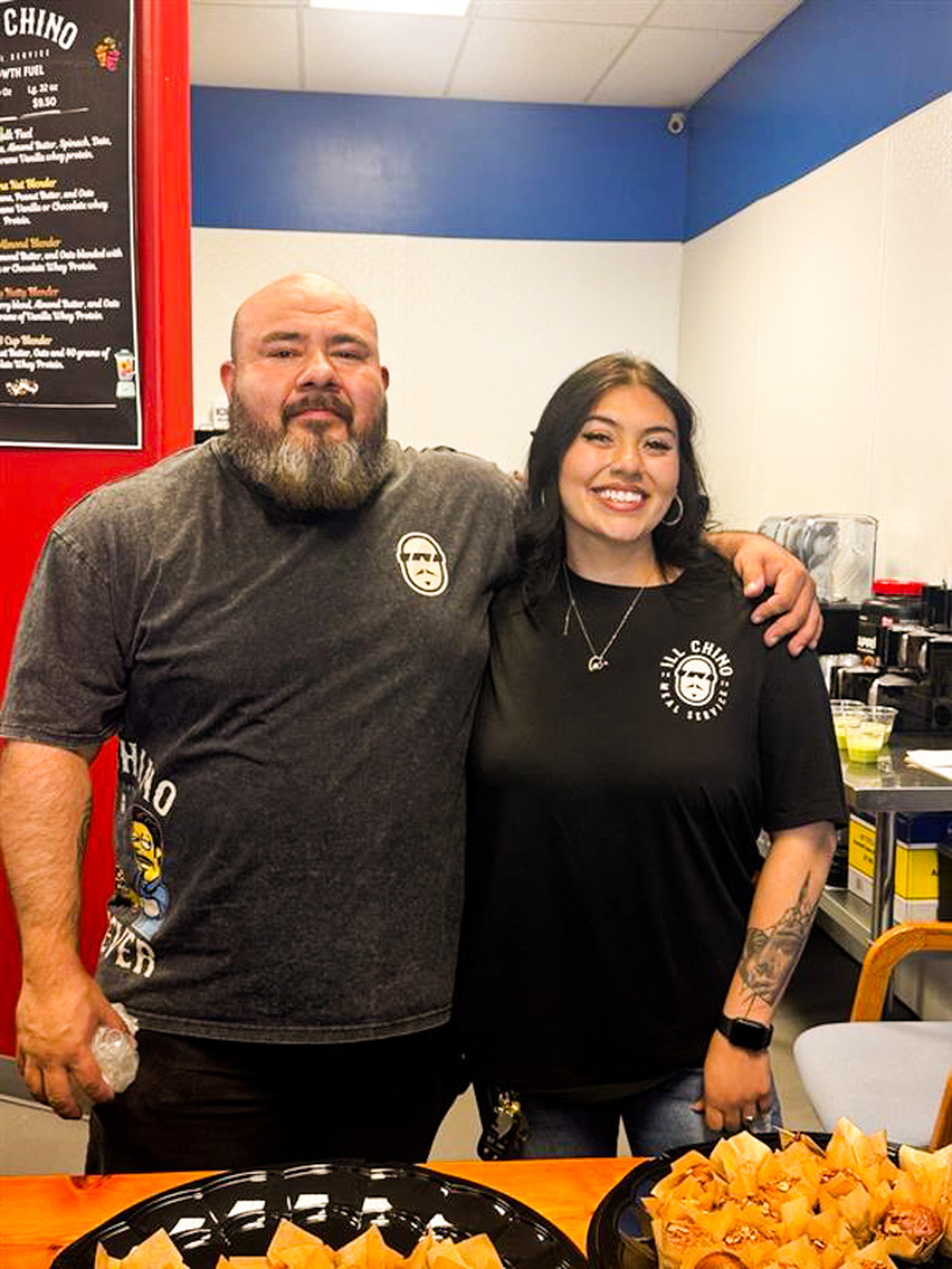 Two Ill Chino Meal Service team members smile for a photo during the Husband & Wife Law Team’s HEART event, welcoming guests and sharing their passion for healthy meals and community connection.