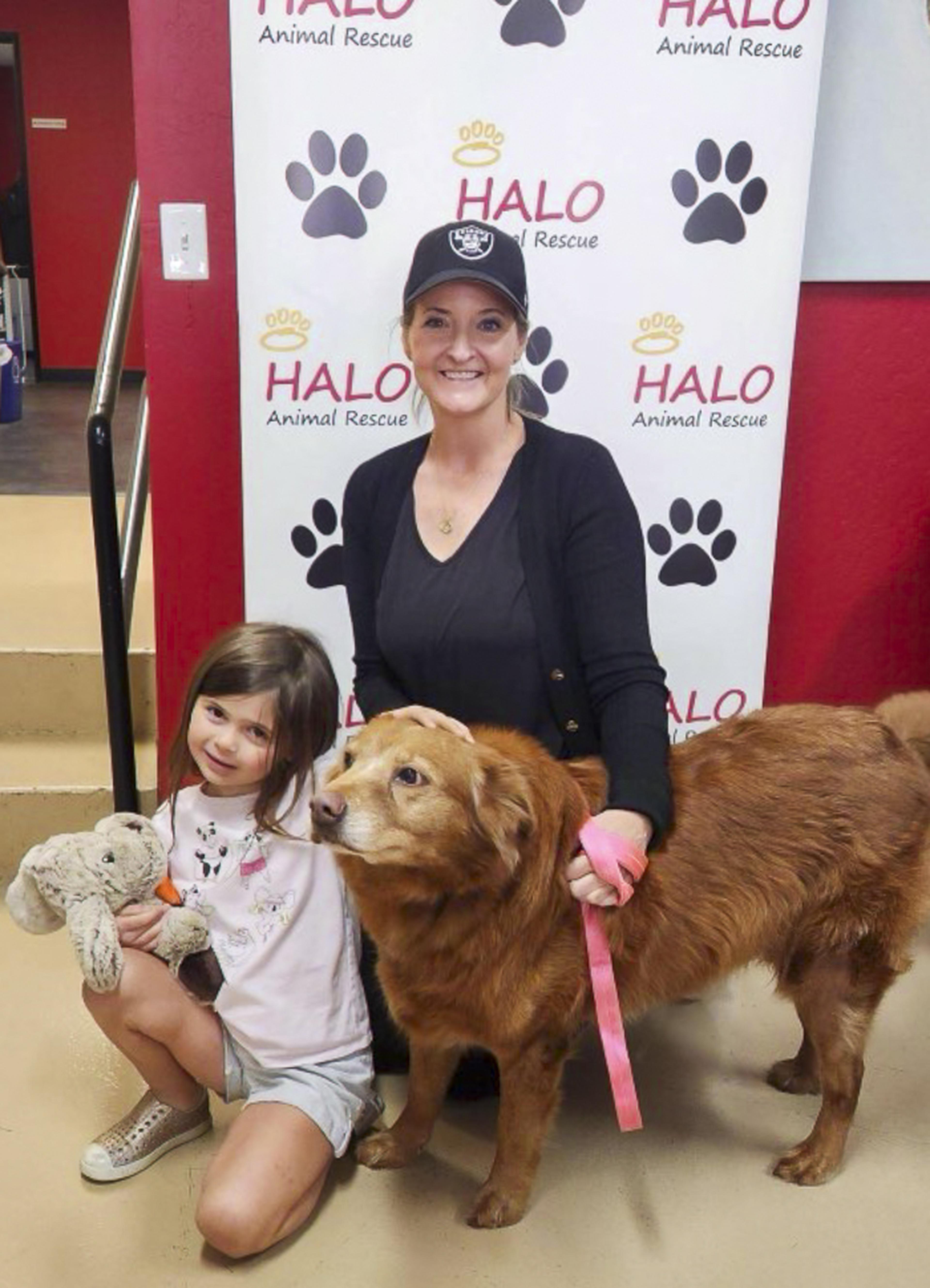 A woman and young girl pose with their adopted dog at the Husband & Wife Law Team’s HALO Adoption Event, celebrating a special day and the start of a new journey together.