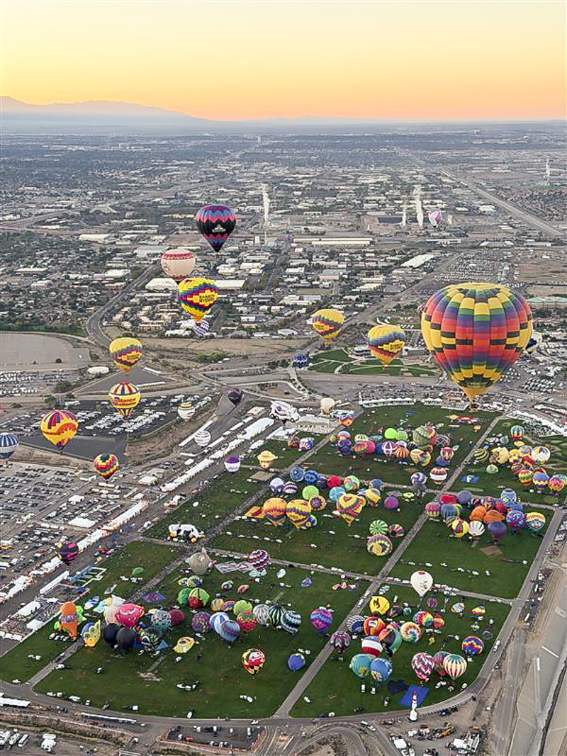 Hundreds of colorful hot air balloons fill the Albuquerque sky at sunrise during the Albuquerque International Balloon Fiesta.