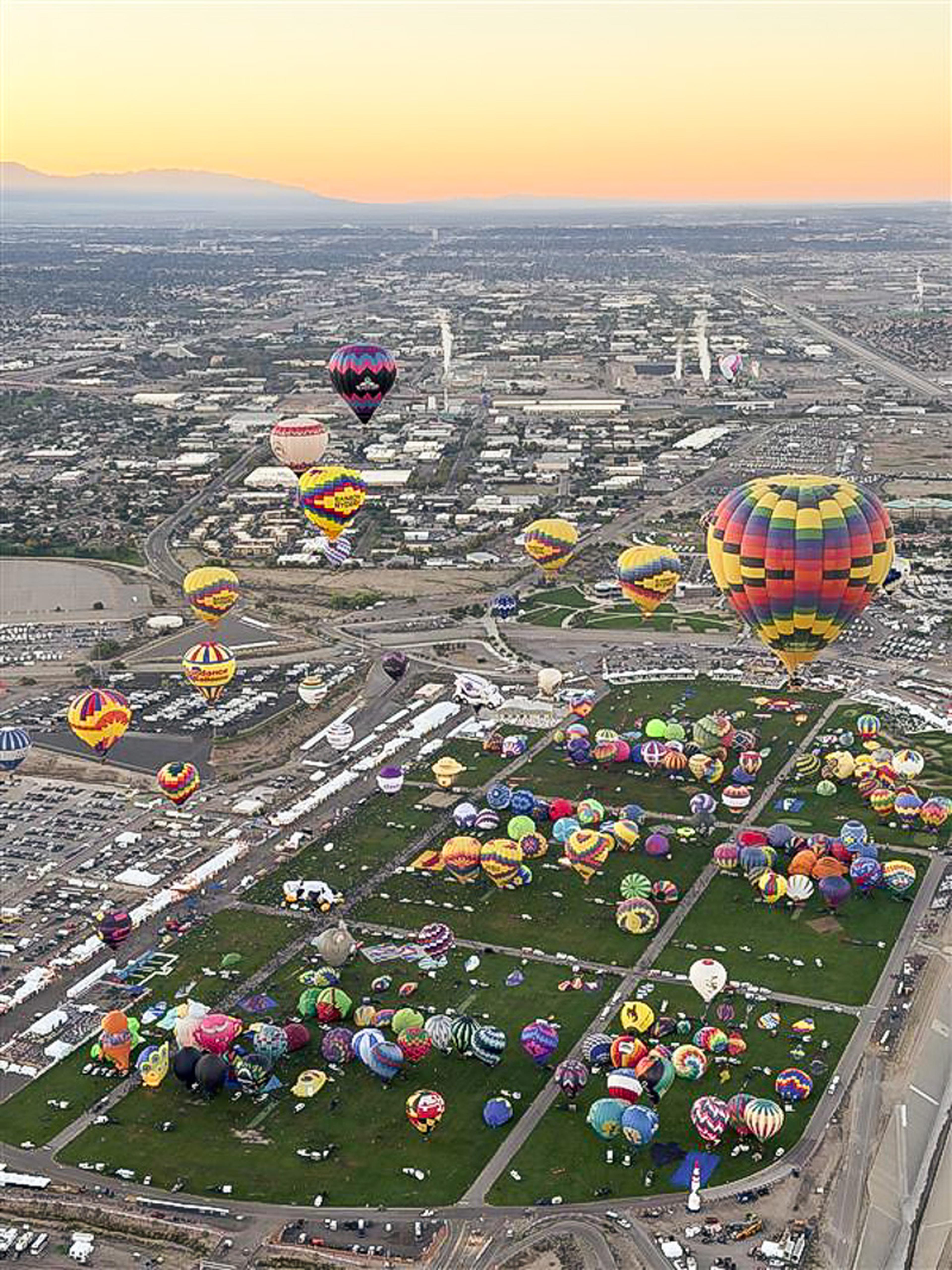 Hundreds of colorful hot air balloons fill the Albuquerque sky at sunrise during the Albuquerque International Balloon Fiesta.