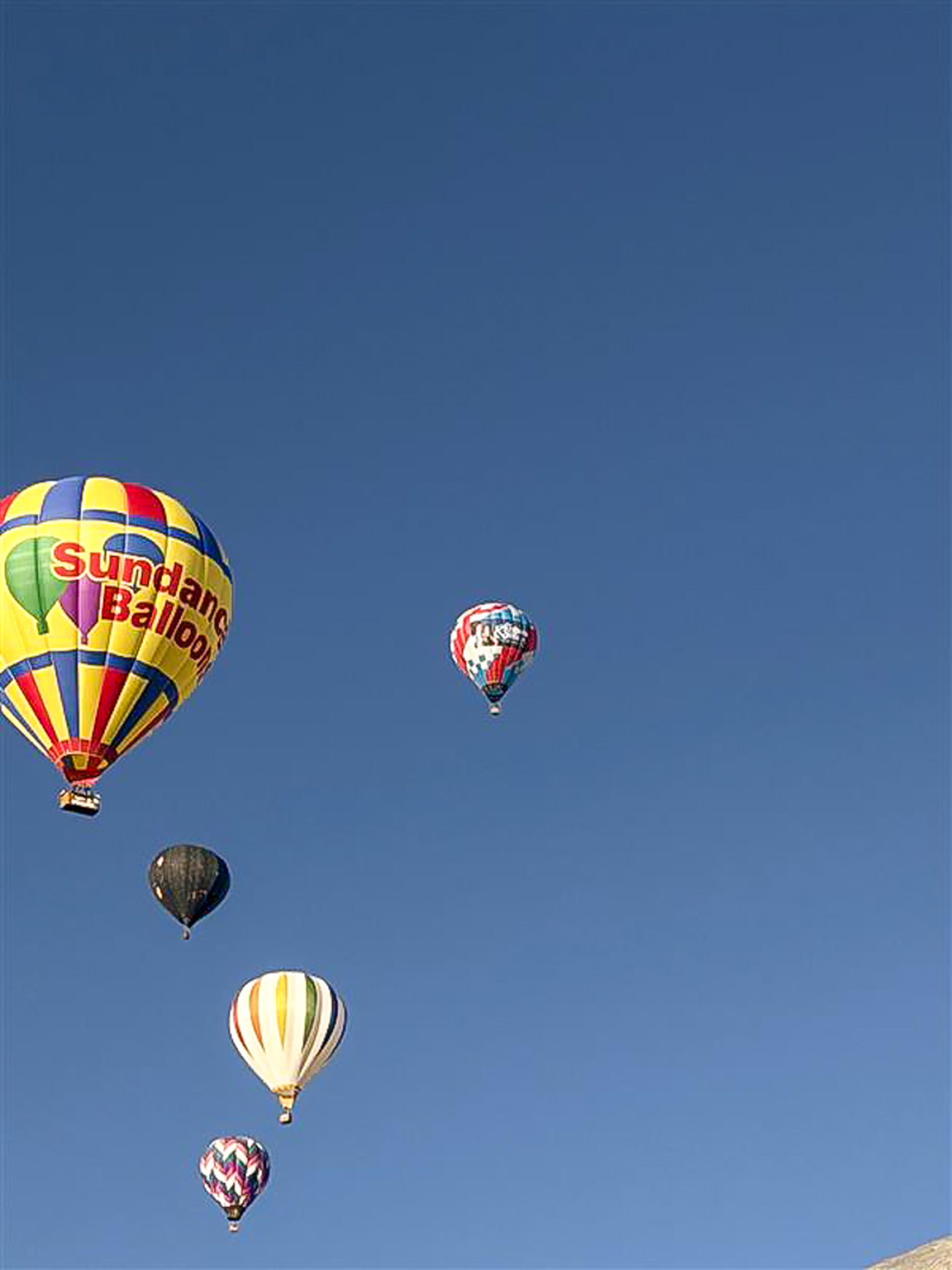Colorful hot air balloons fill the clear blue sky during the Albuquerque International Balloon Fiesta.