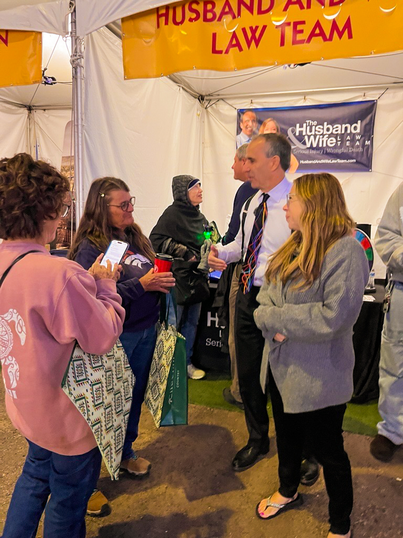 Visitors stop by the Husband & Wife Law Team booth to meet Mark and Alexis Breyer during the Albuquerque International Balloon Fiesta.