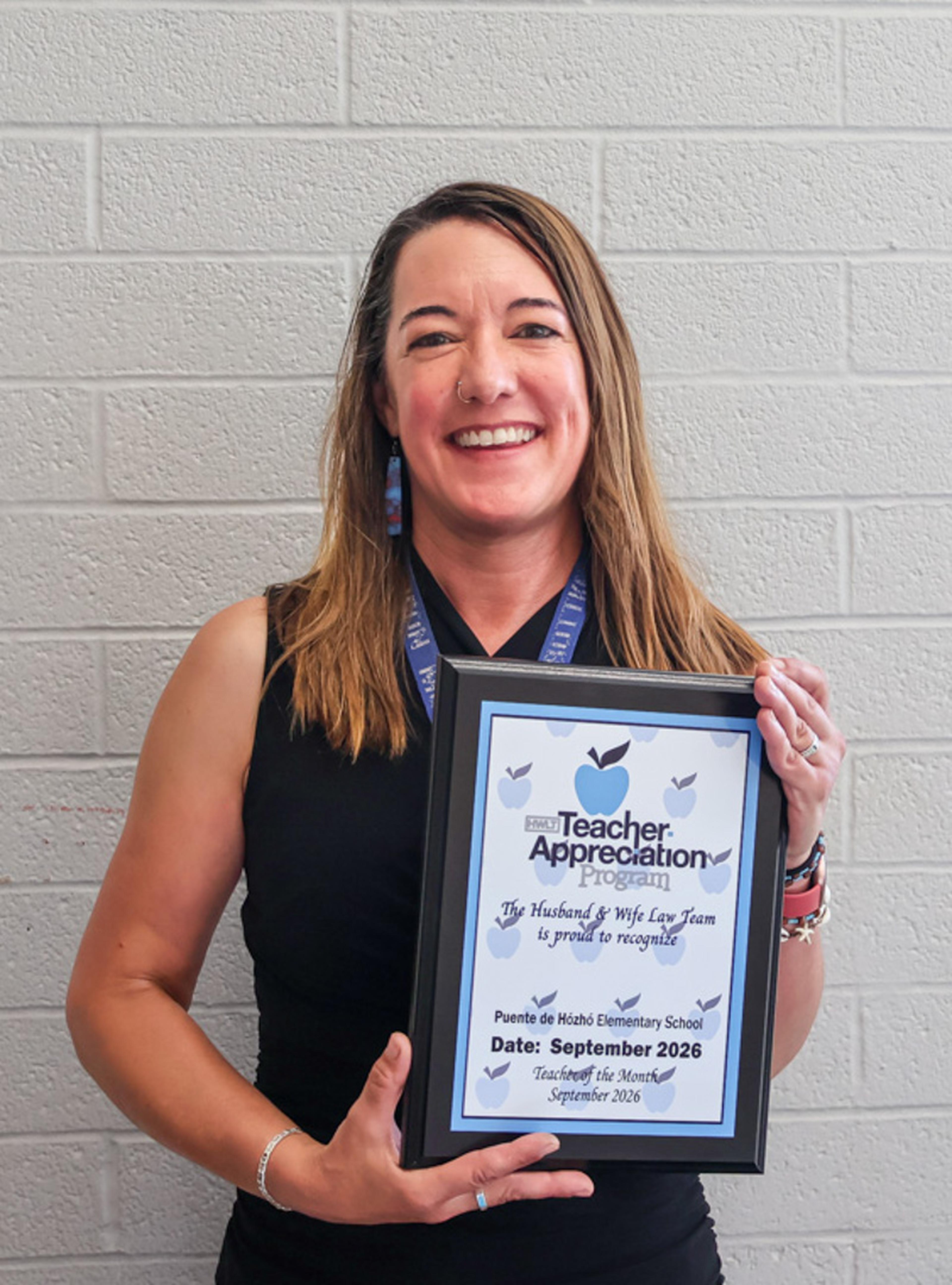 Ms. Bottke proudly holds her Teacher of the Month certificate, celebrating recognition for her dedication, leadership, and positive impact on students at Puente de Hózhó Elementary.