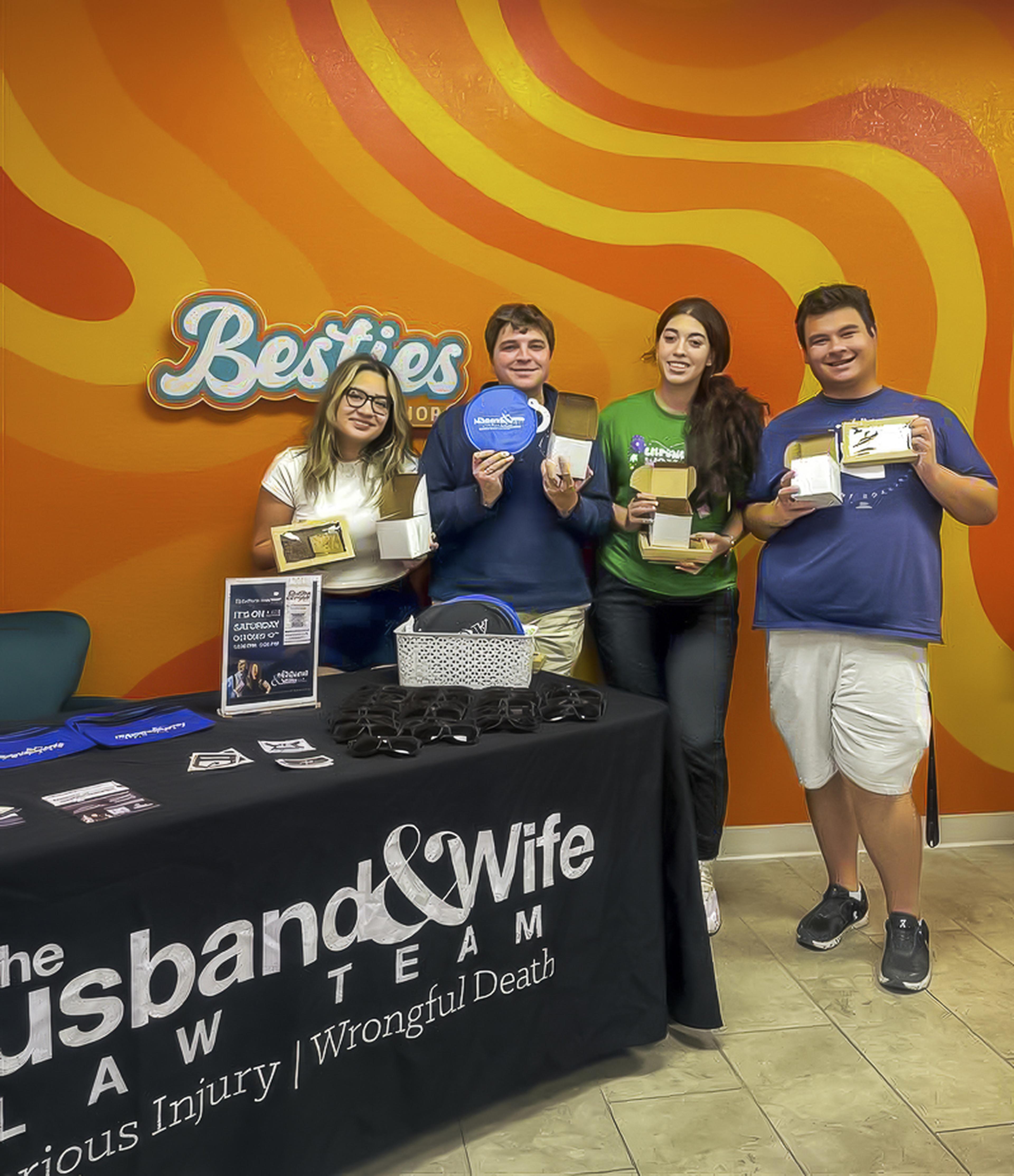 Four attendees gather at Besties Bakeshop during the Husband & Wife Law Team’s HEART event, enjoying giveaways and community connection.